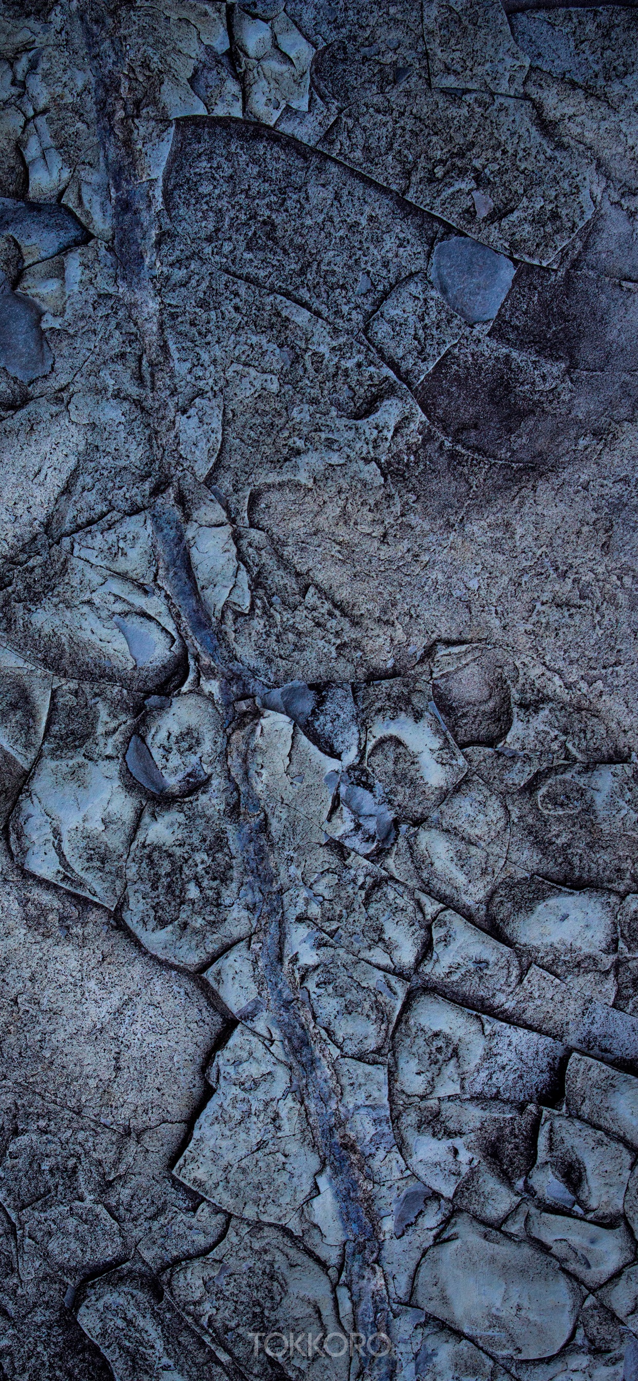 Close-up of a cracked rock surface with blue veins HD Phone Wallpaper
