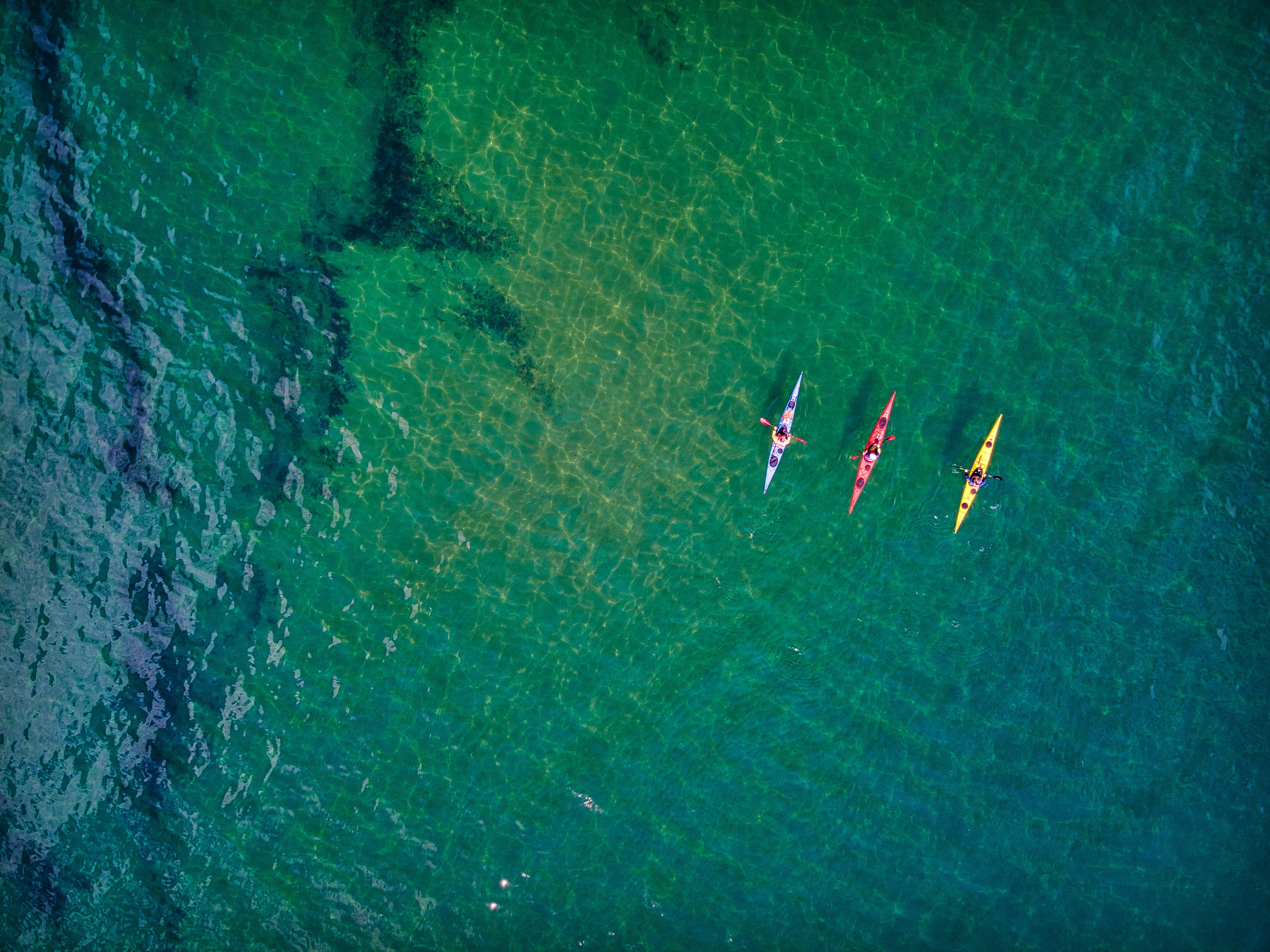 Three kayaks on clear water near Jurassic Coast, Devon, UK HD Wallpaper