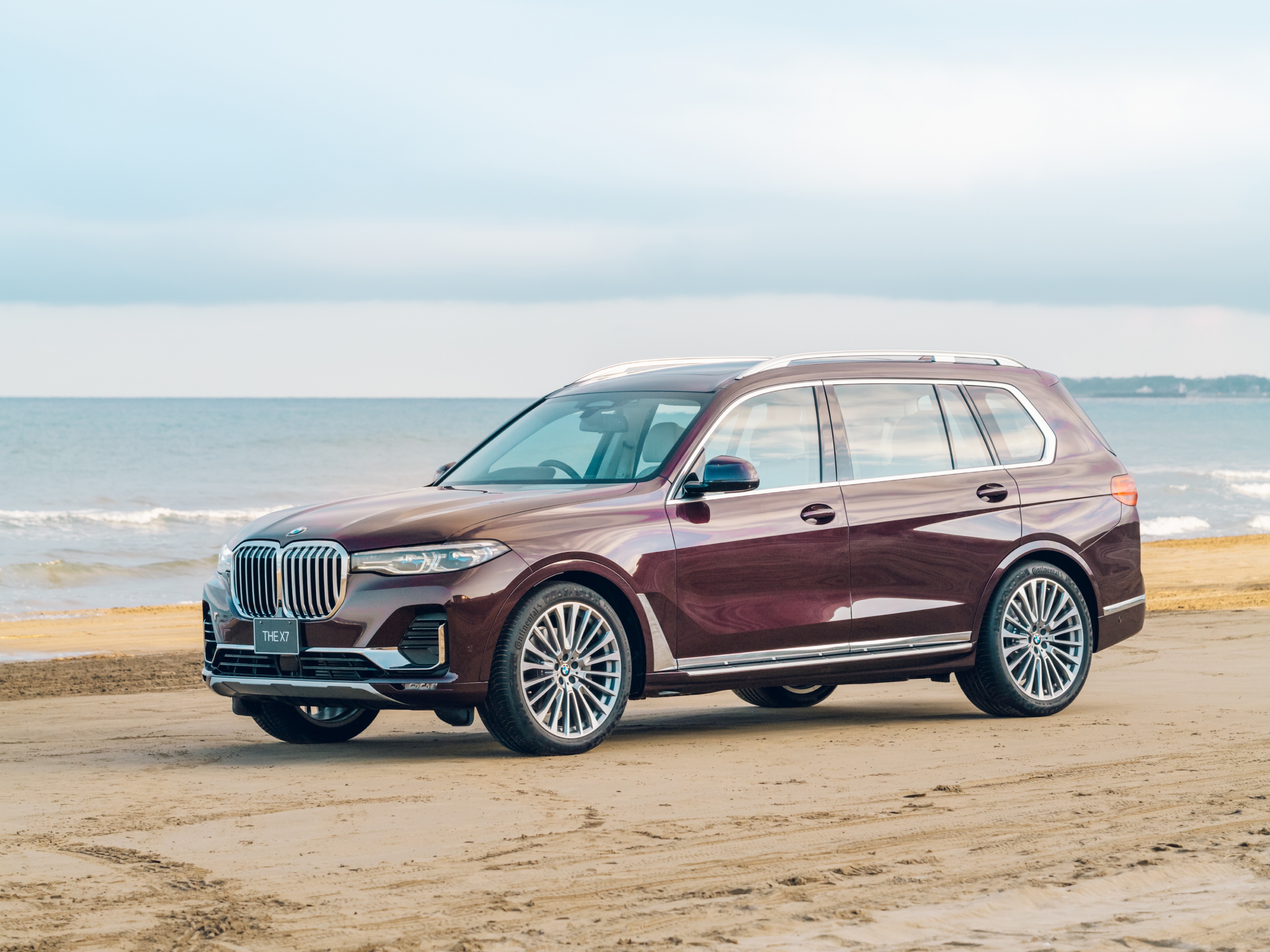 Maroon BMW X7 SUV parked on a beach HD Wallpaper