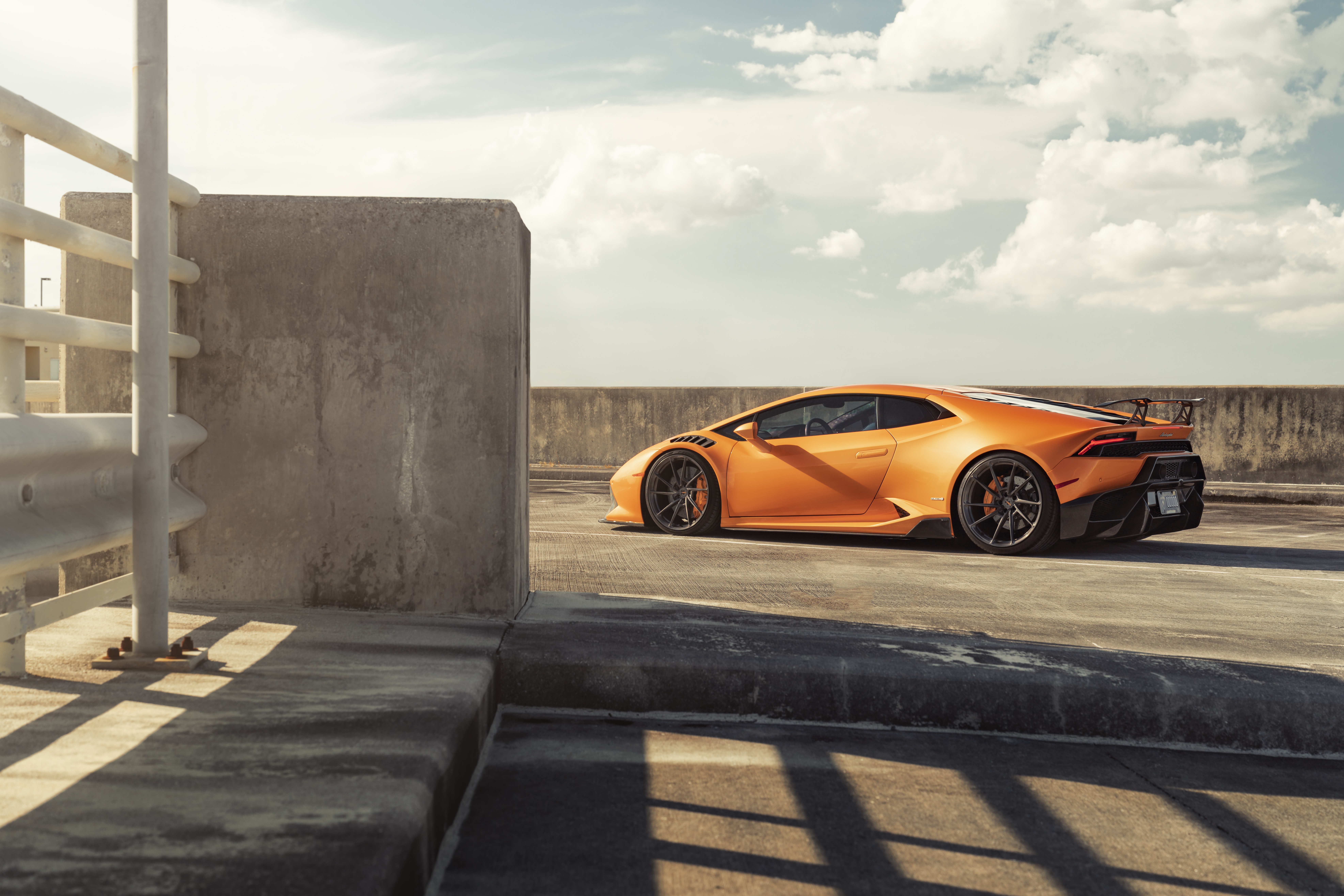 Orange Lamborghini Huracan on rooftop parking HD Wallpaper