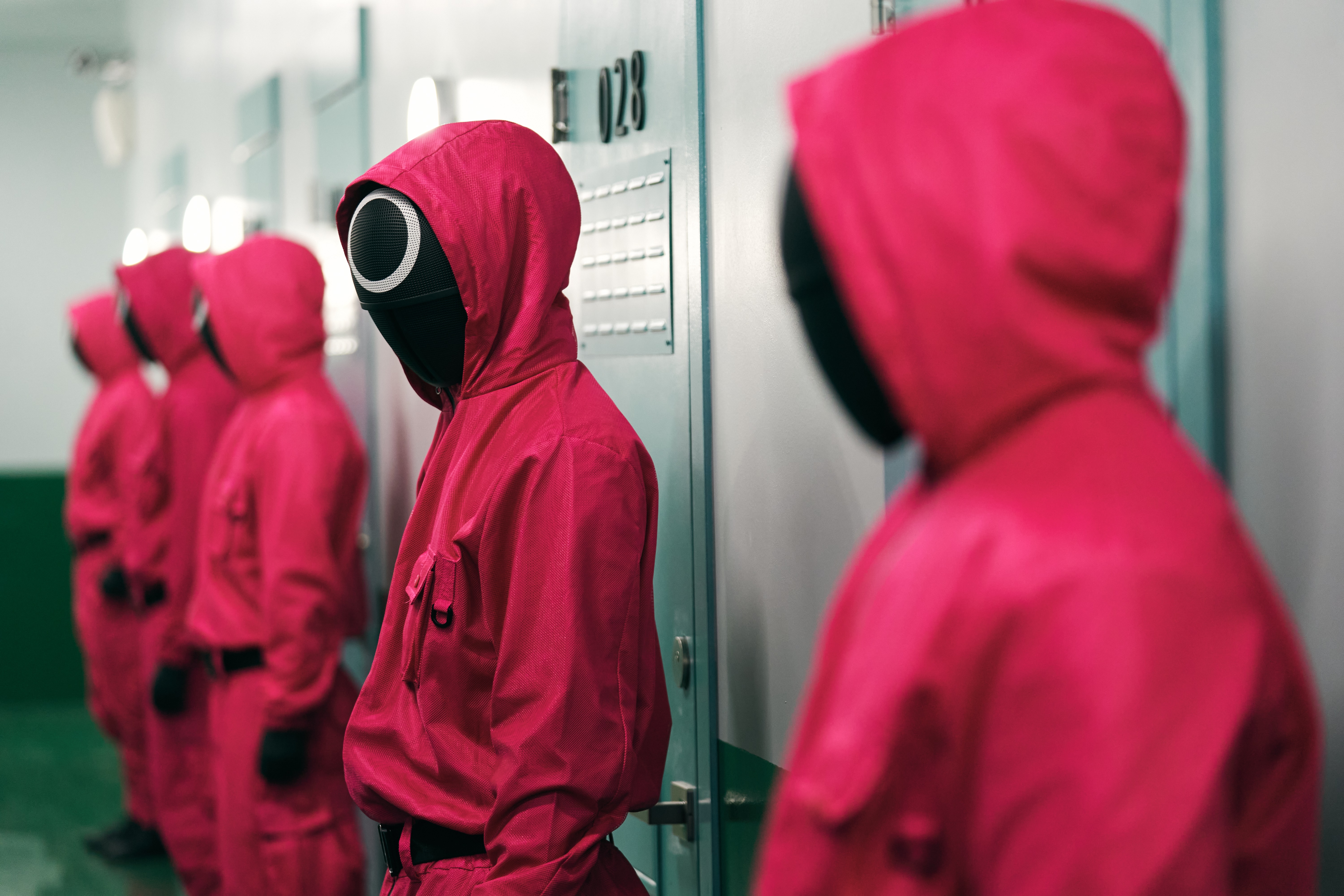Squid Game guards in pink suits and masks HD Wallpaper