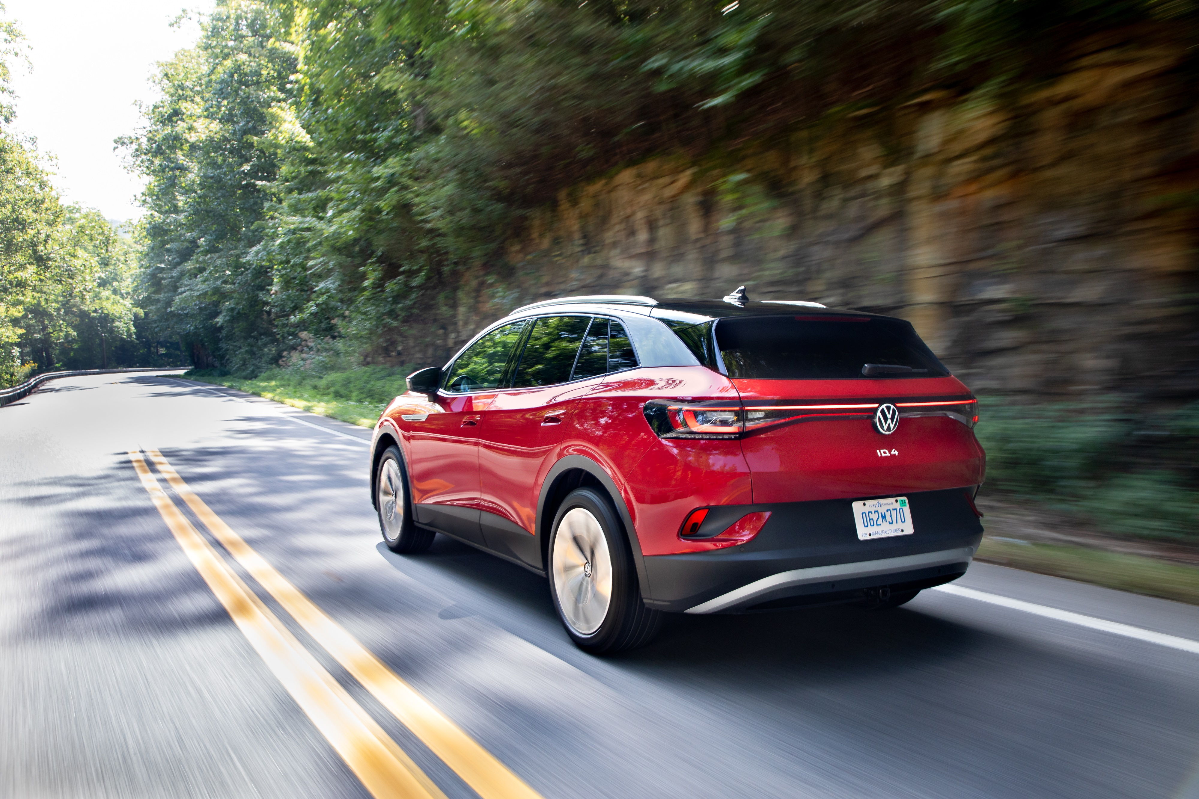 Red Volkswagen ID.4 AWD Pro S driving on a road HD Wallpaper