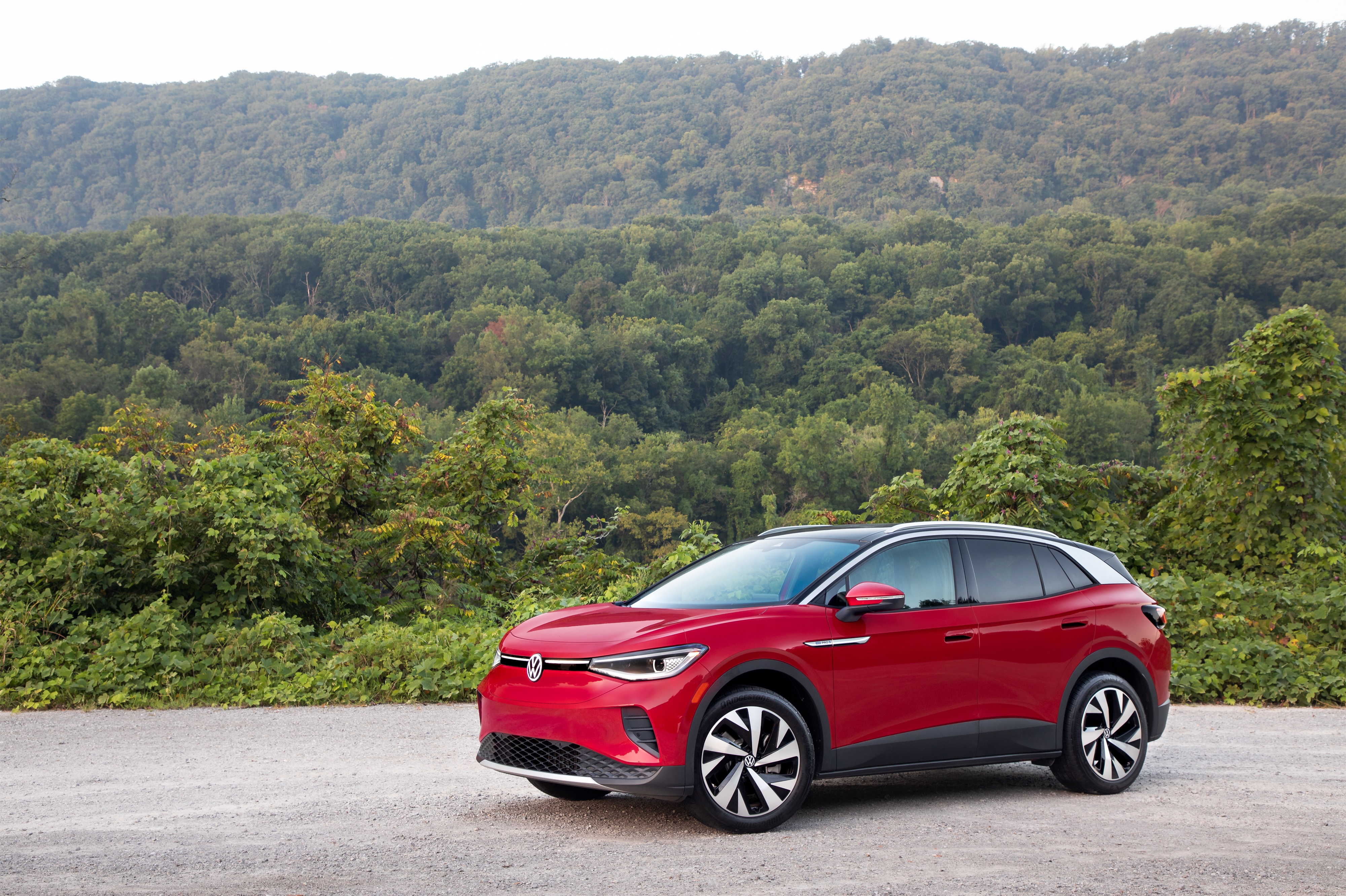 Red Volkswagen ID.4 electric car parked on gravel road HD Wallpaper
