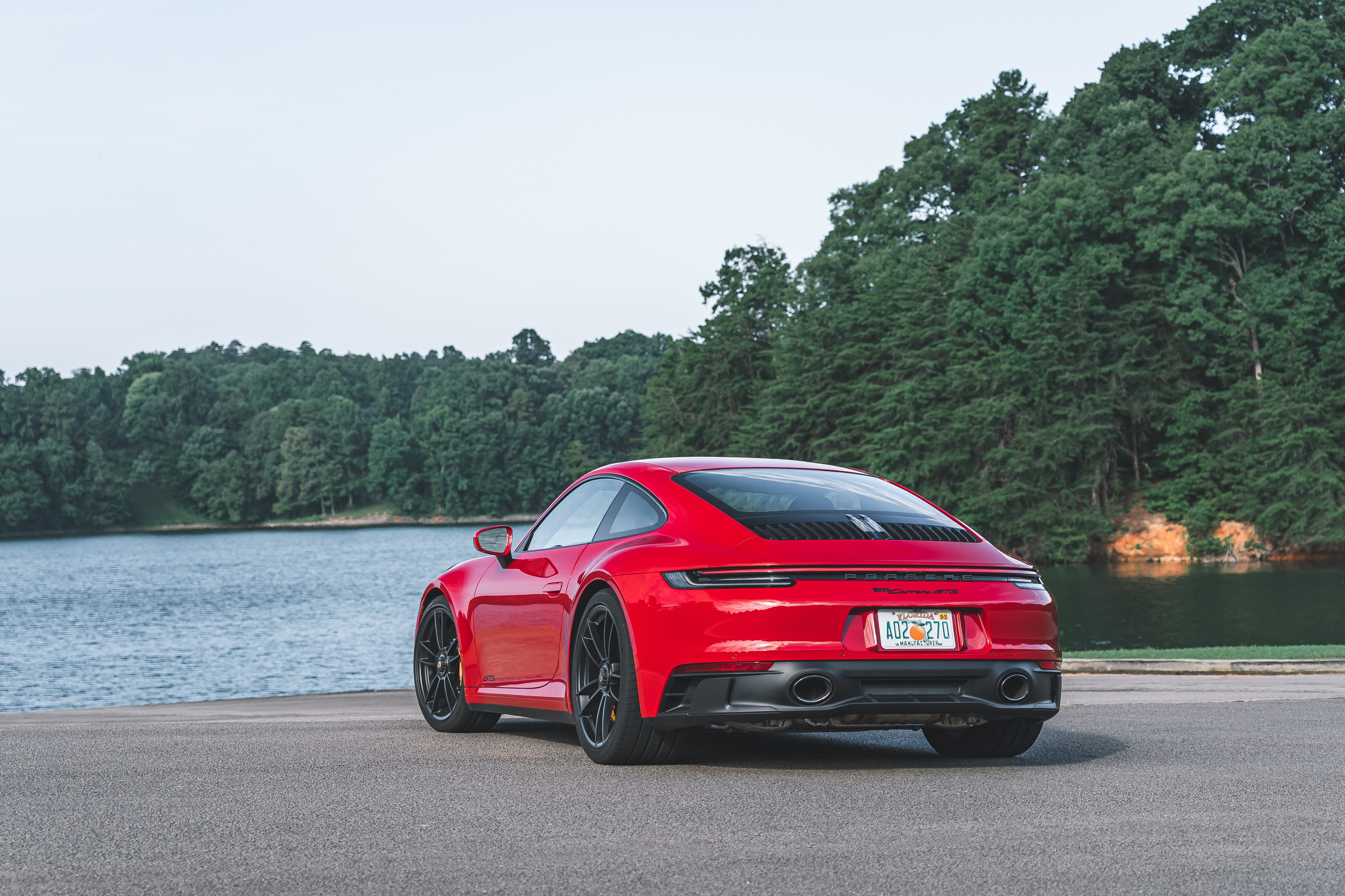 Red Porsche 911 Carrera GTS 4K by a lake HD Wallpaper
