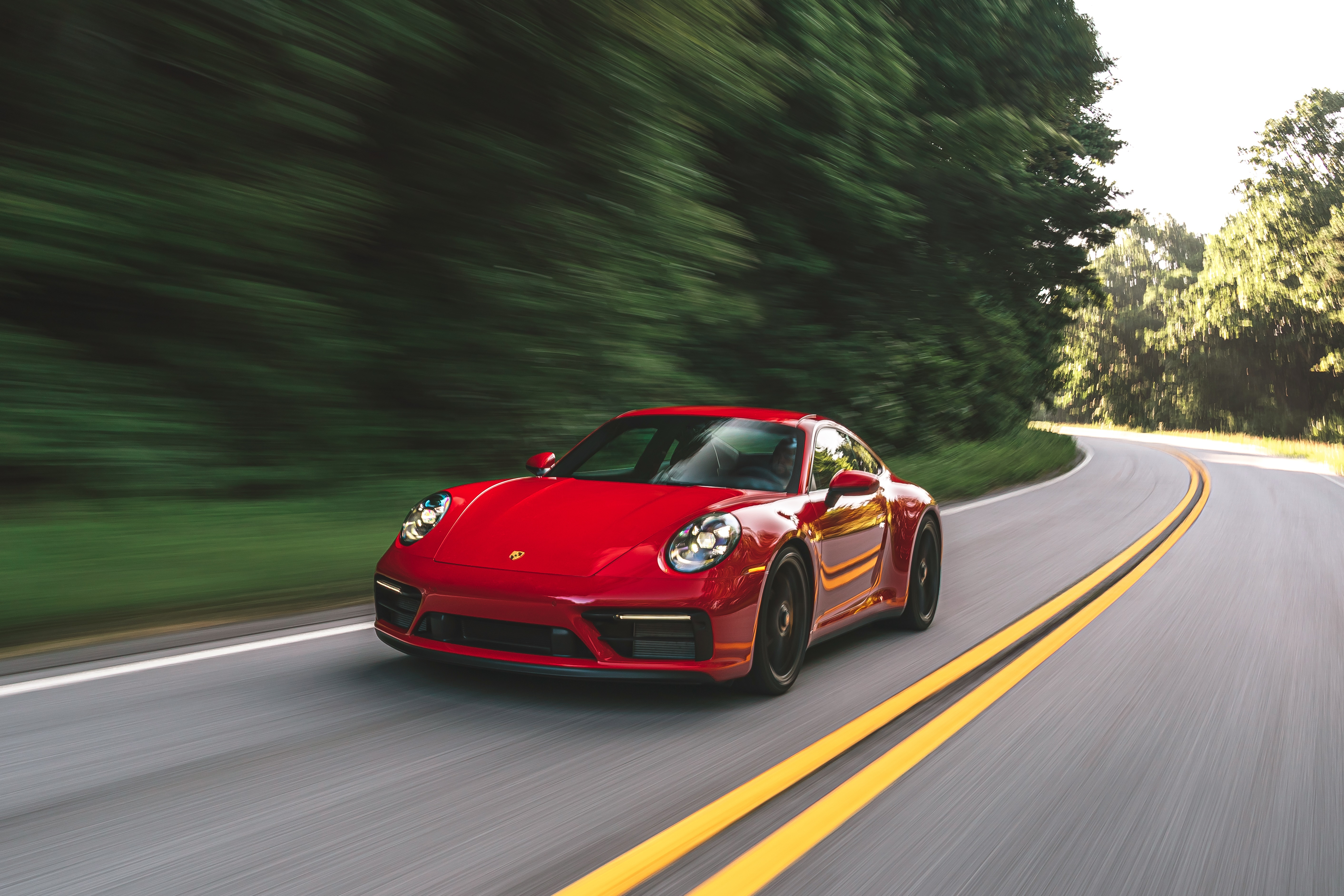 Red Porsche 911 Carrera GTS driving on a road HD Wallpaper