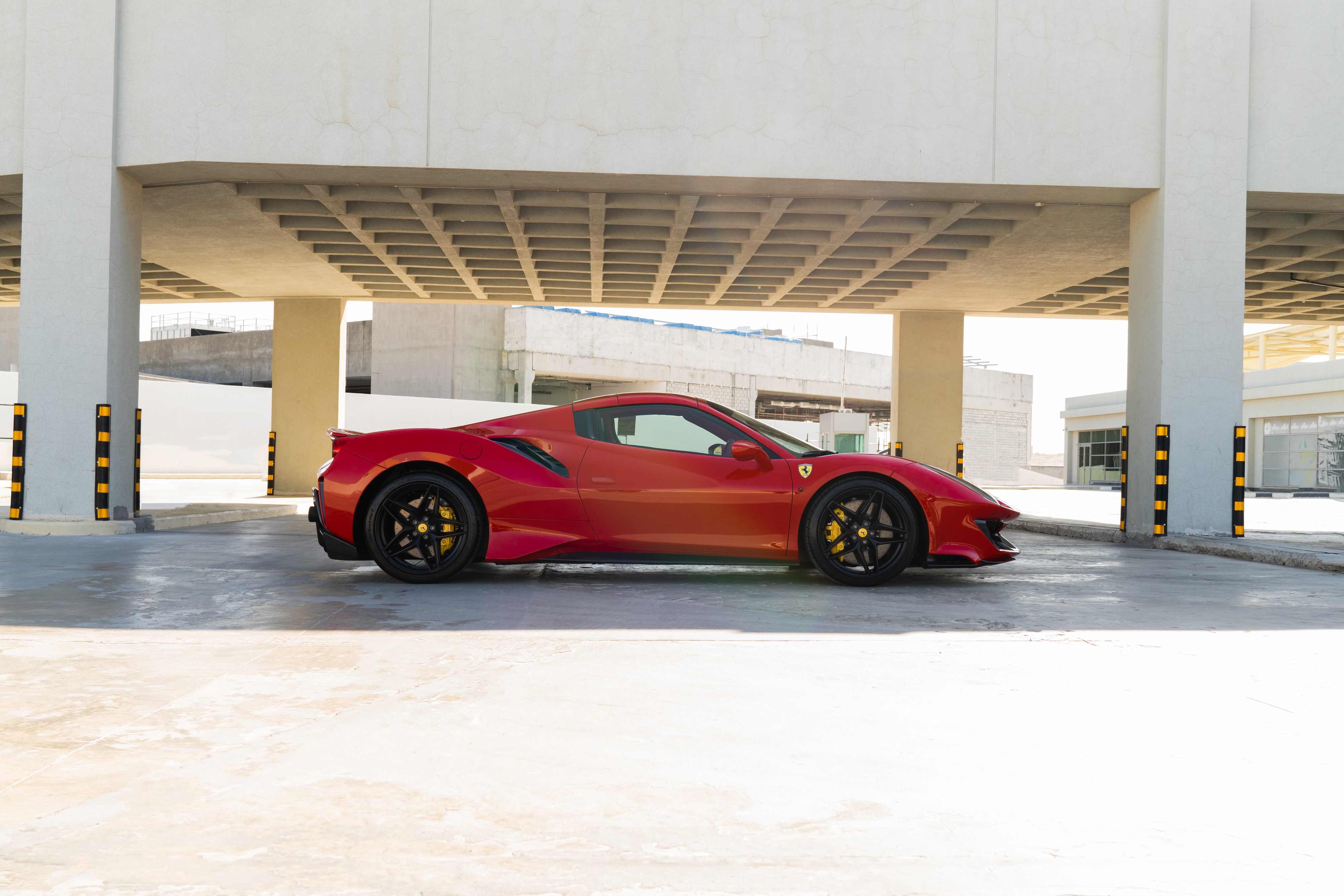 Red Ferrari 488 Pista Spider parked under a concrete structure HD Wallpaper