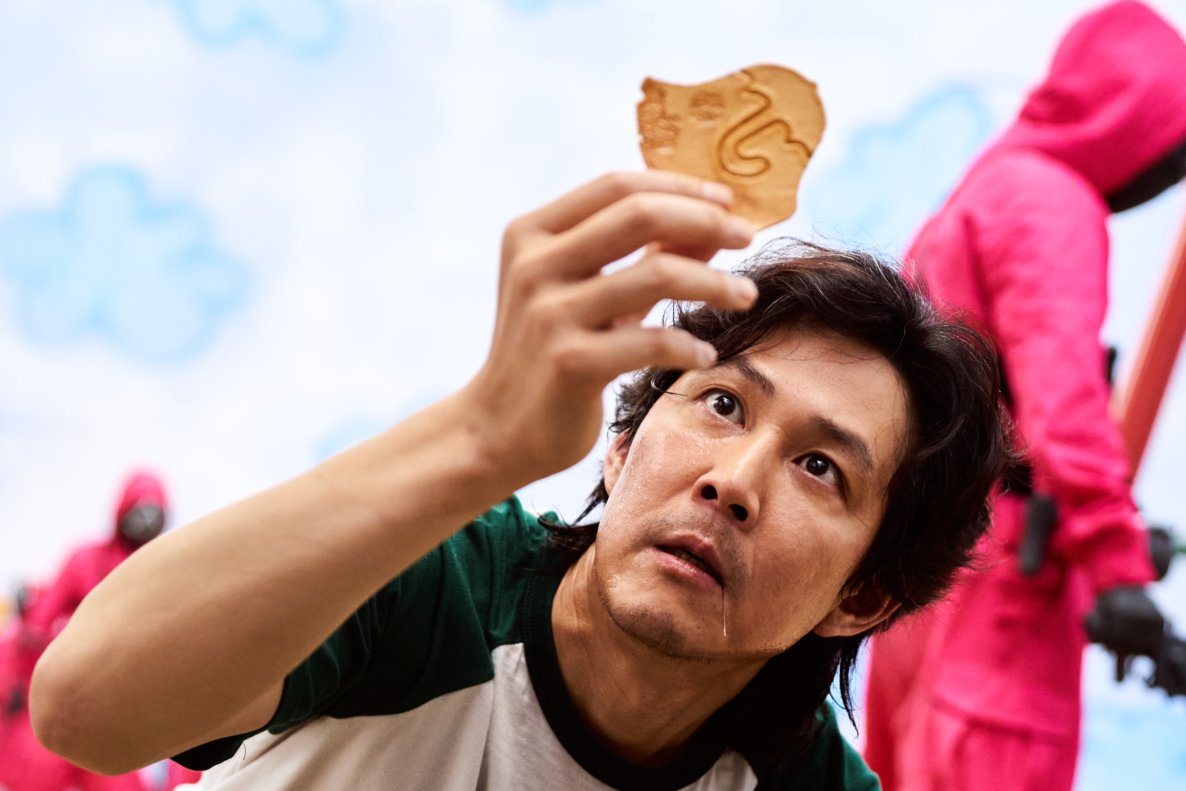 Seong Gi-Hun from Squid Game holding a cookie HD Wallpaper