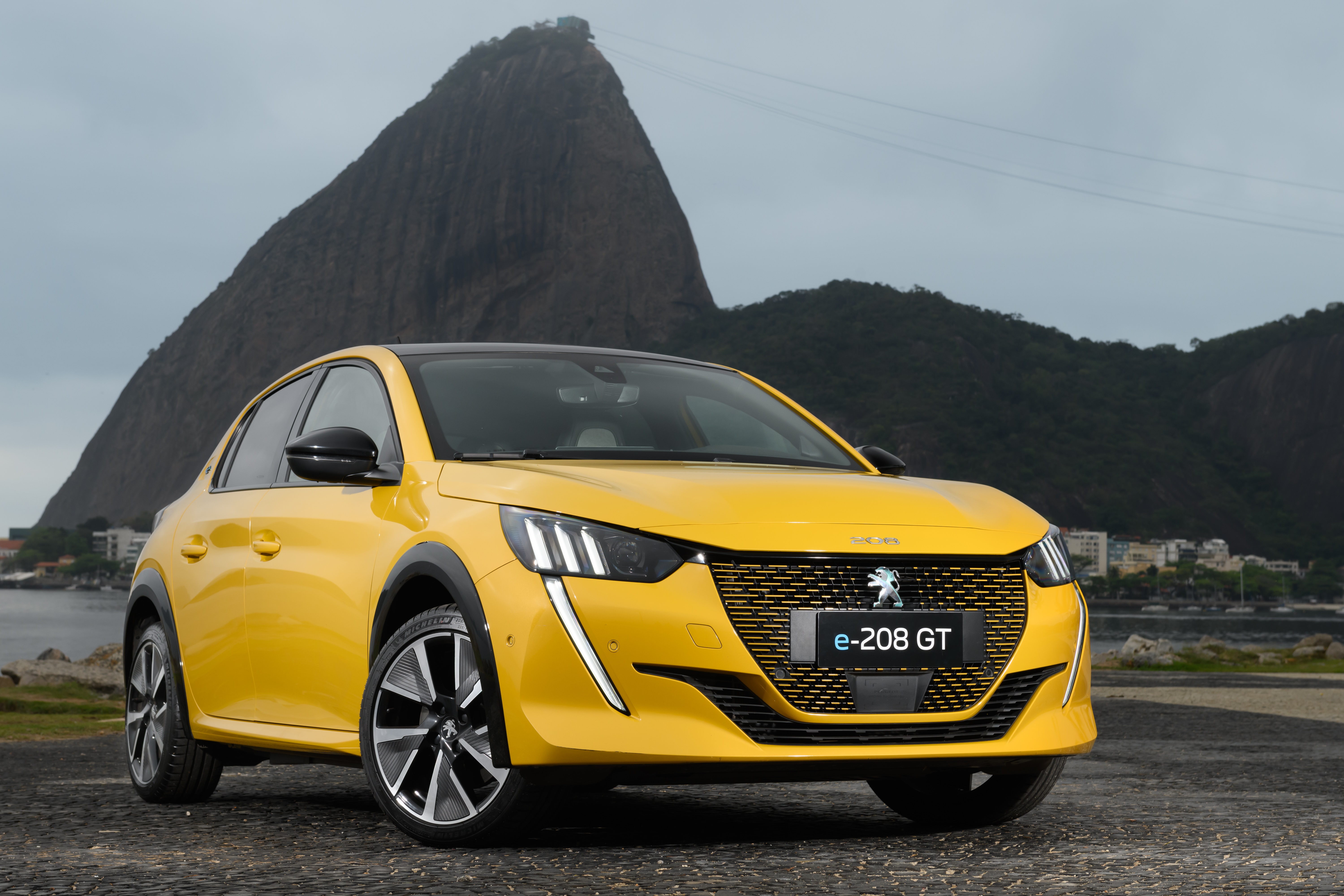 Yellow Peugeot e-208 GT electric car in Rio de Janeiro HD Wallpaper