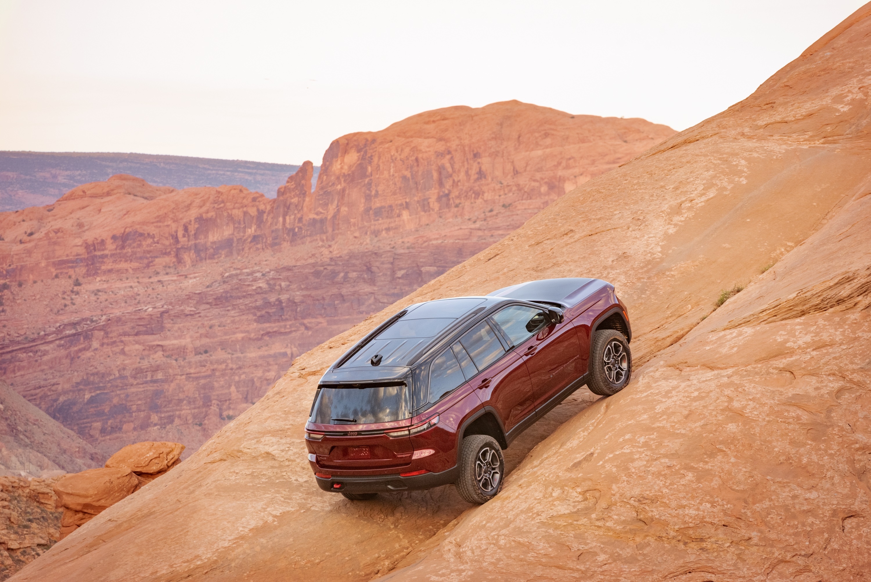 2022 Jeep Grand Cherokee Trailhawk driving on a rocky incline HD Wallpaper