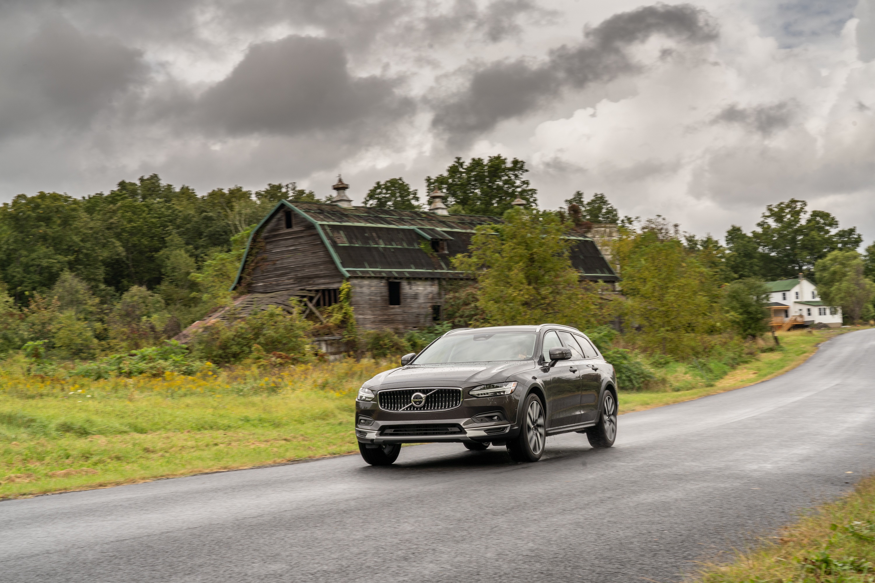Volvo V90 B6 AWD driving past a barn HD Wallpaper