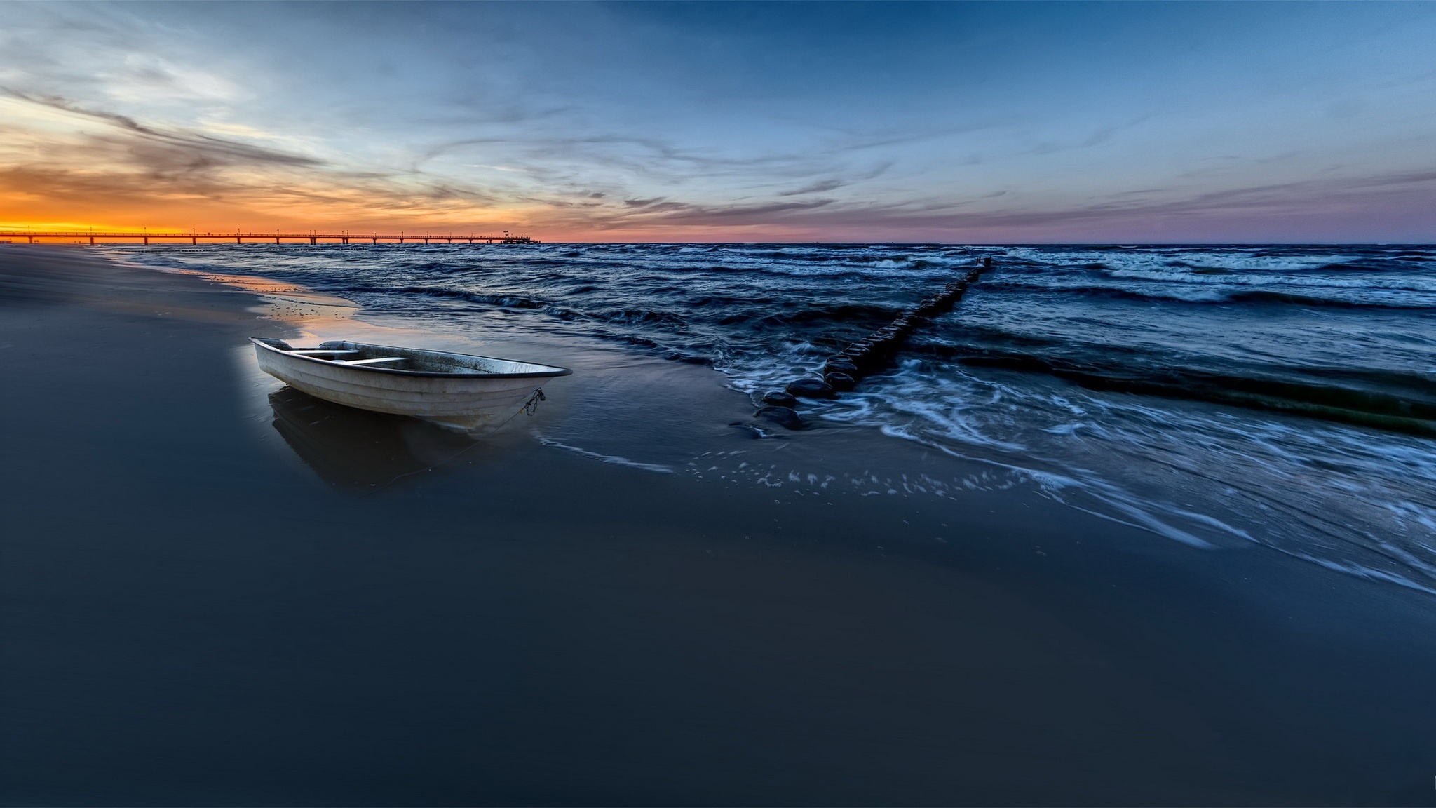 Boat on a beach at sunset with pier HD Wallpaper