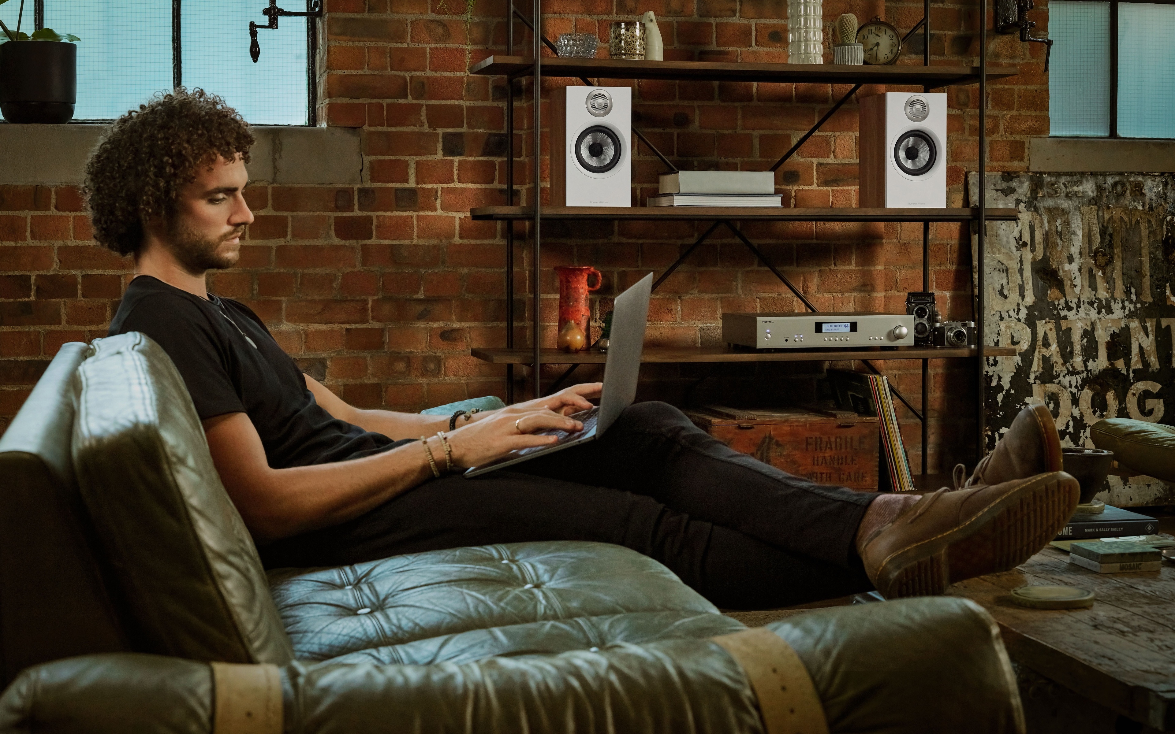 Man on couch with laptop and speakers HD Wallpaper