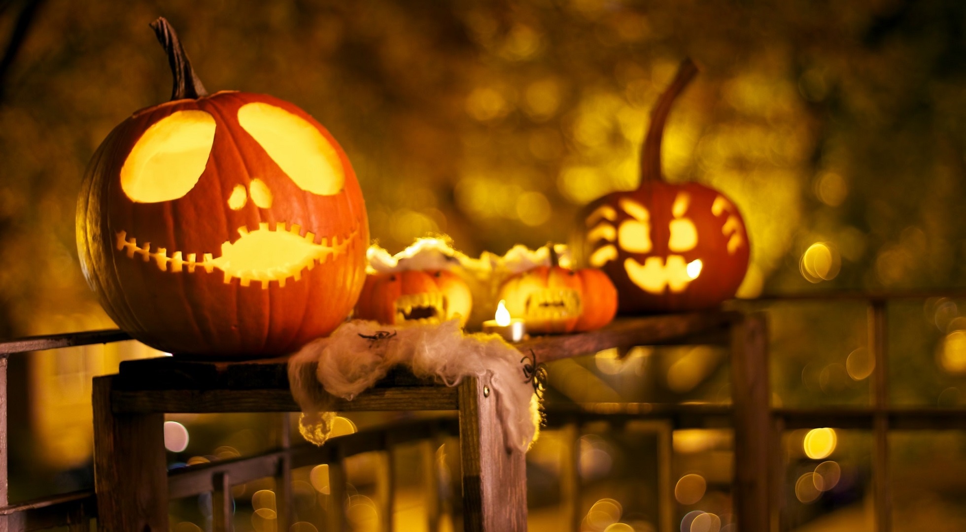 Carved Jack-o'-lanterns on a railing at night HD Wallpaper