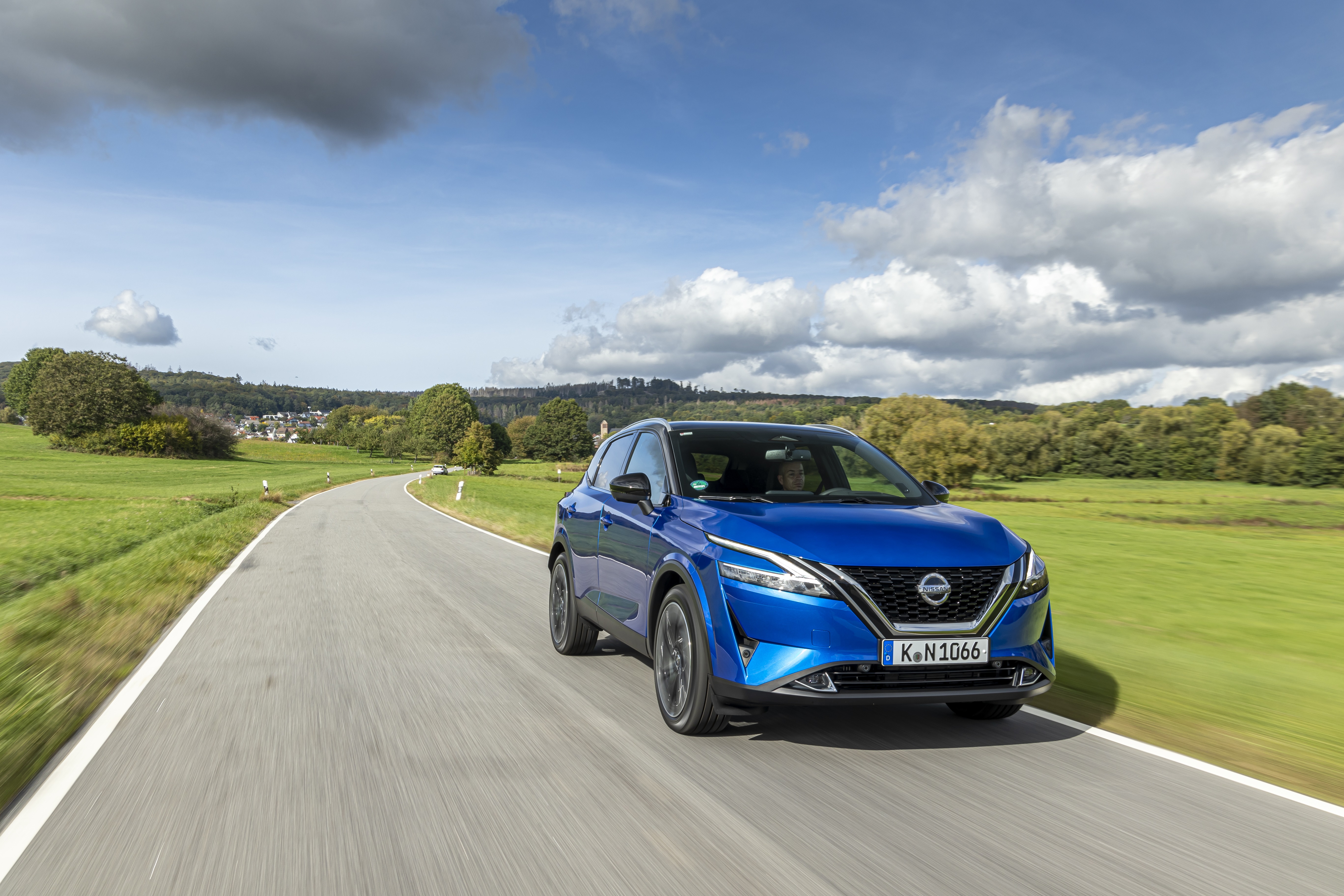 Blue Nissan Qashqai driving on a country road HD Wallpaper