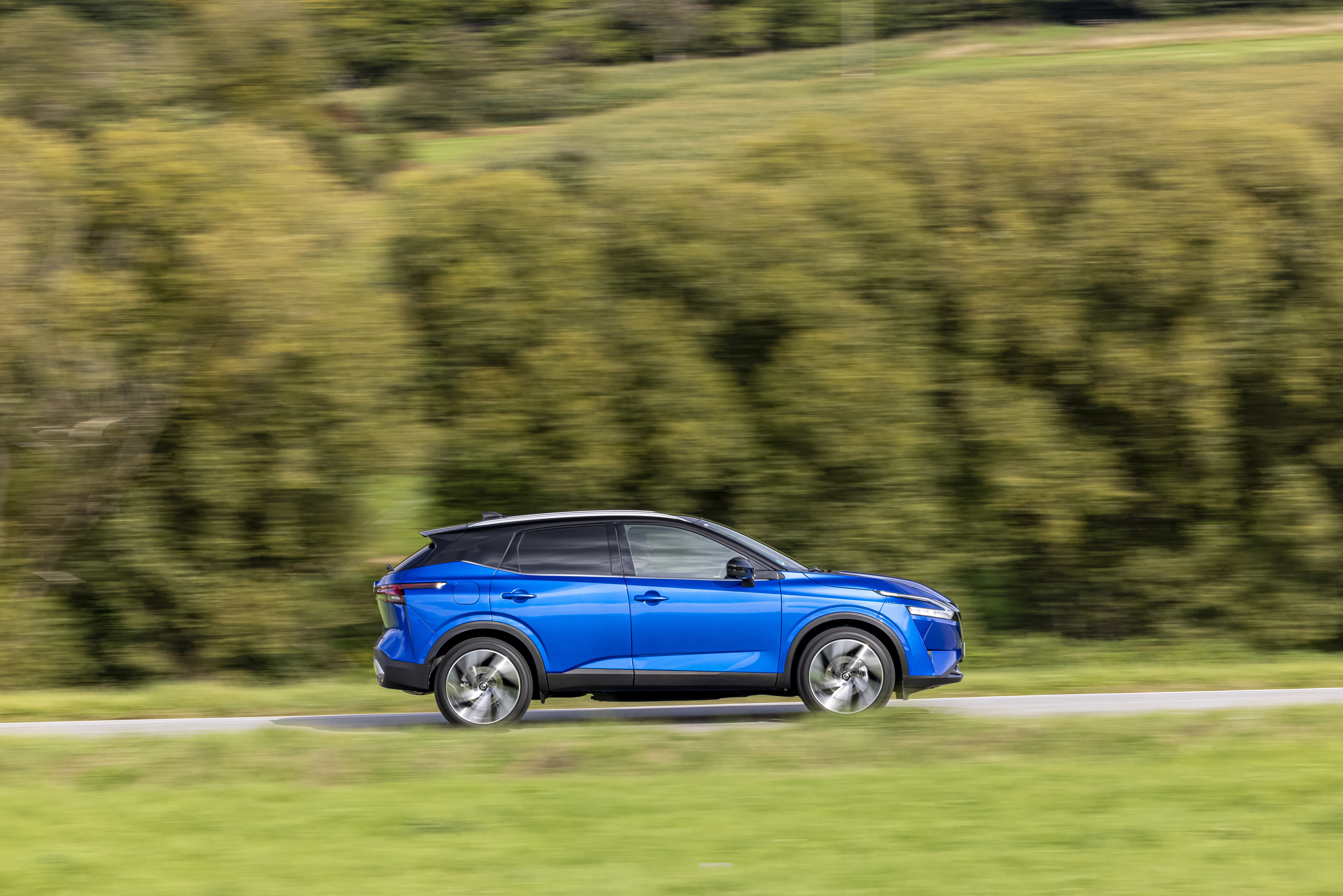 Blue Nissan Qashqai driving on a road HD Wallpaper