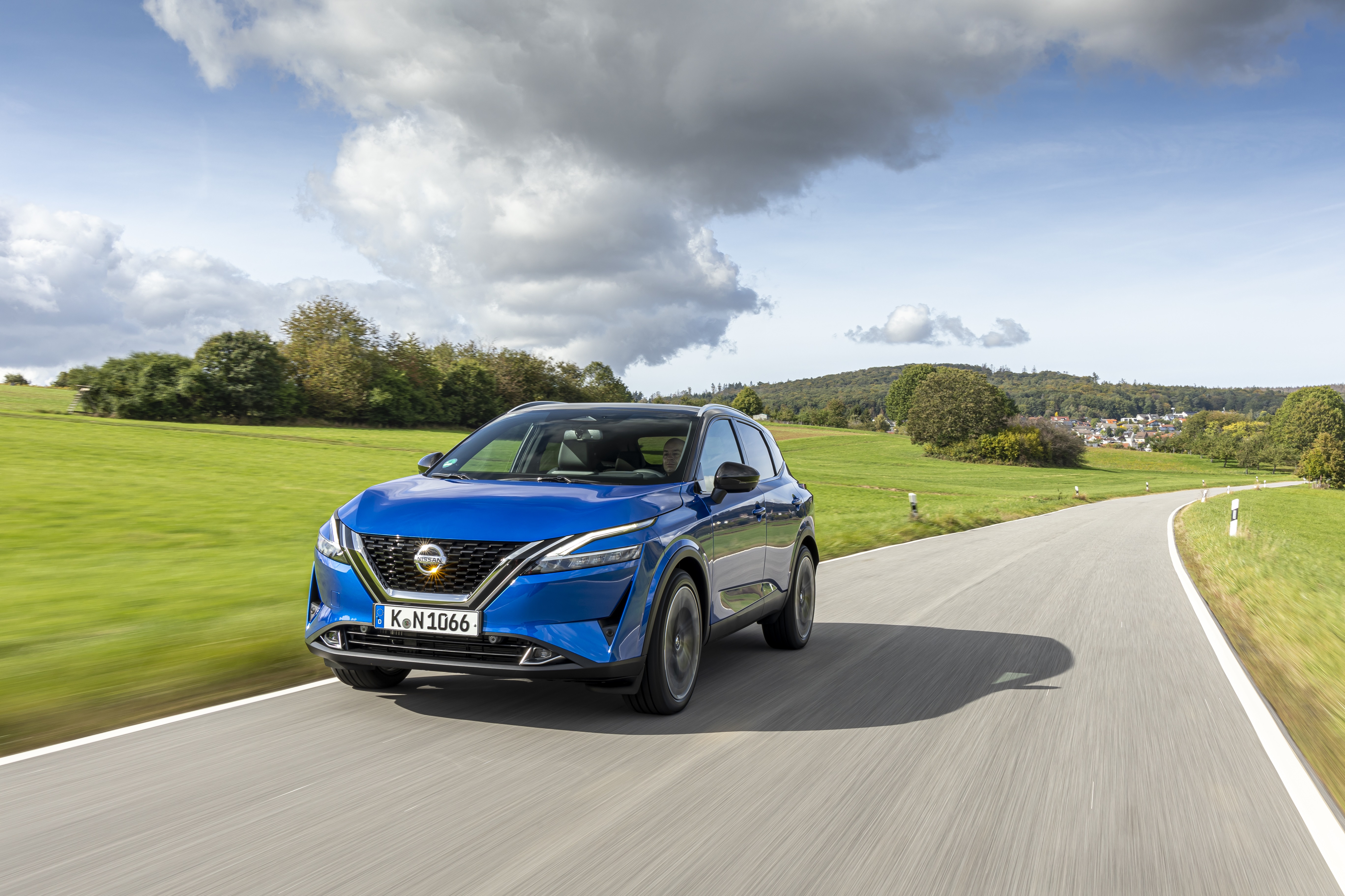 Blue Nissan Qashqai SUV driving on a country road HD Wallpaper
