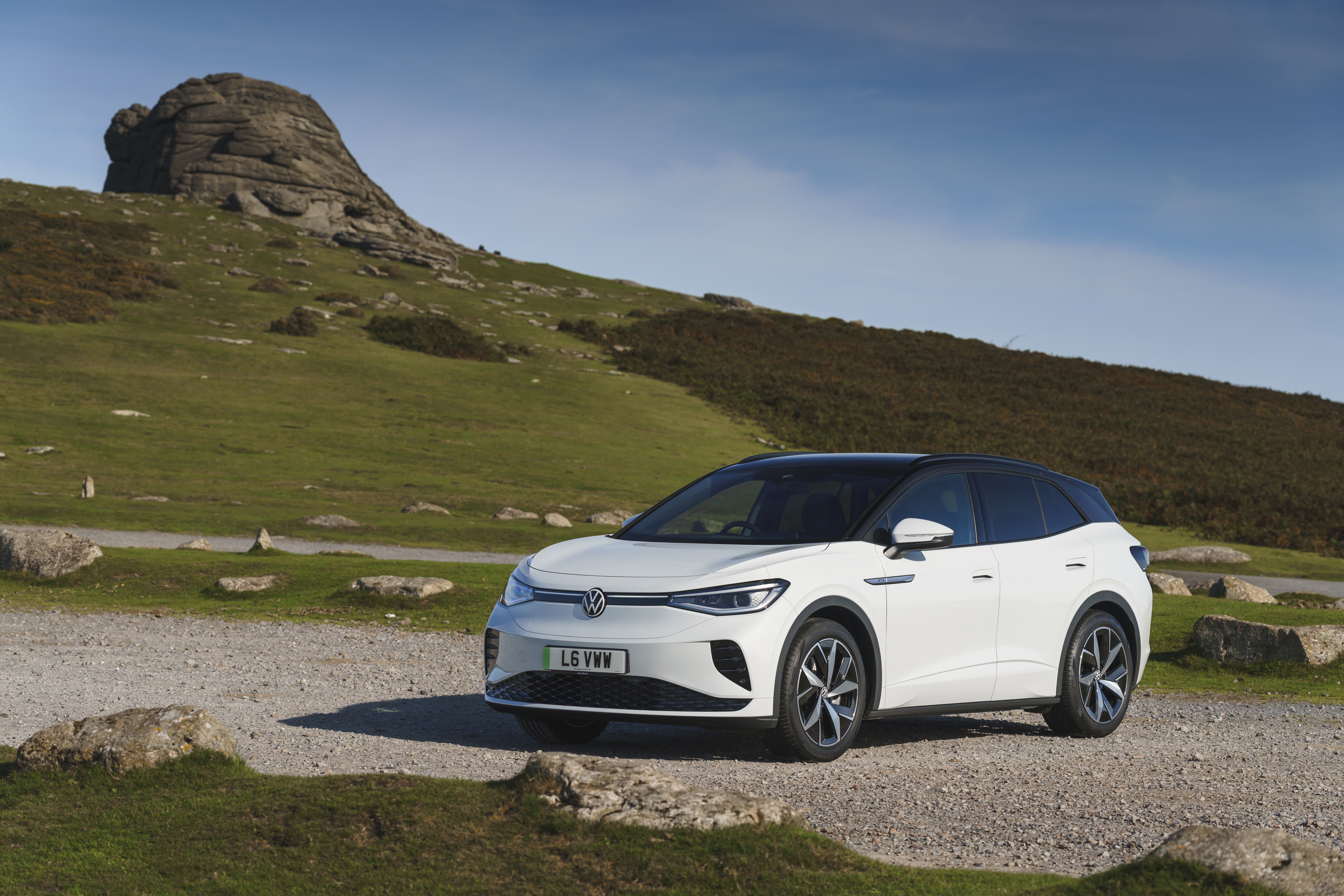 White Volkswagen ID.4 electric car parked on gravel road HD Wallpaper