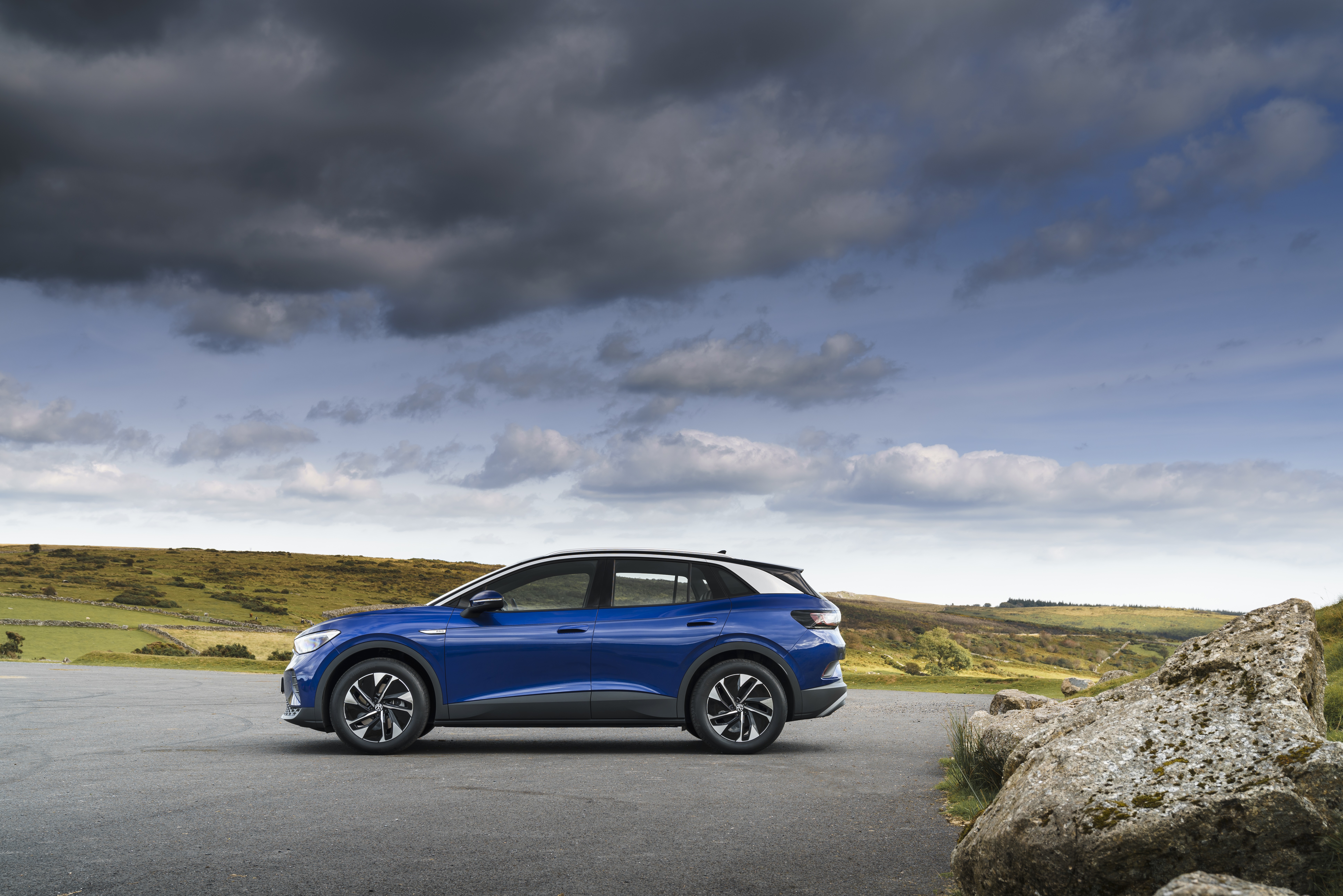 Blue Volkswagen ID.4 electric car parked on asphalt road HD Wallpaper