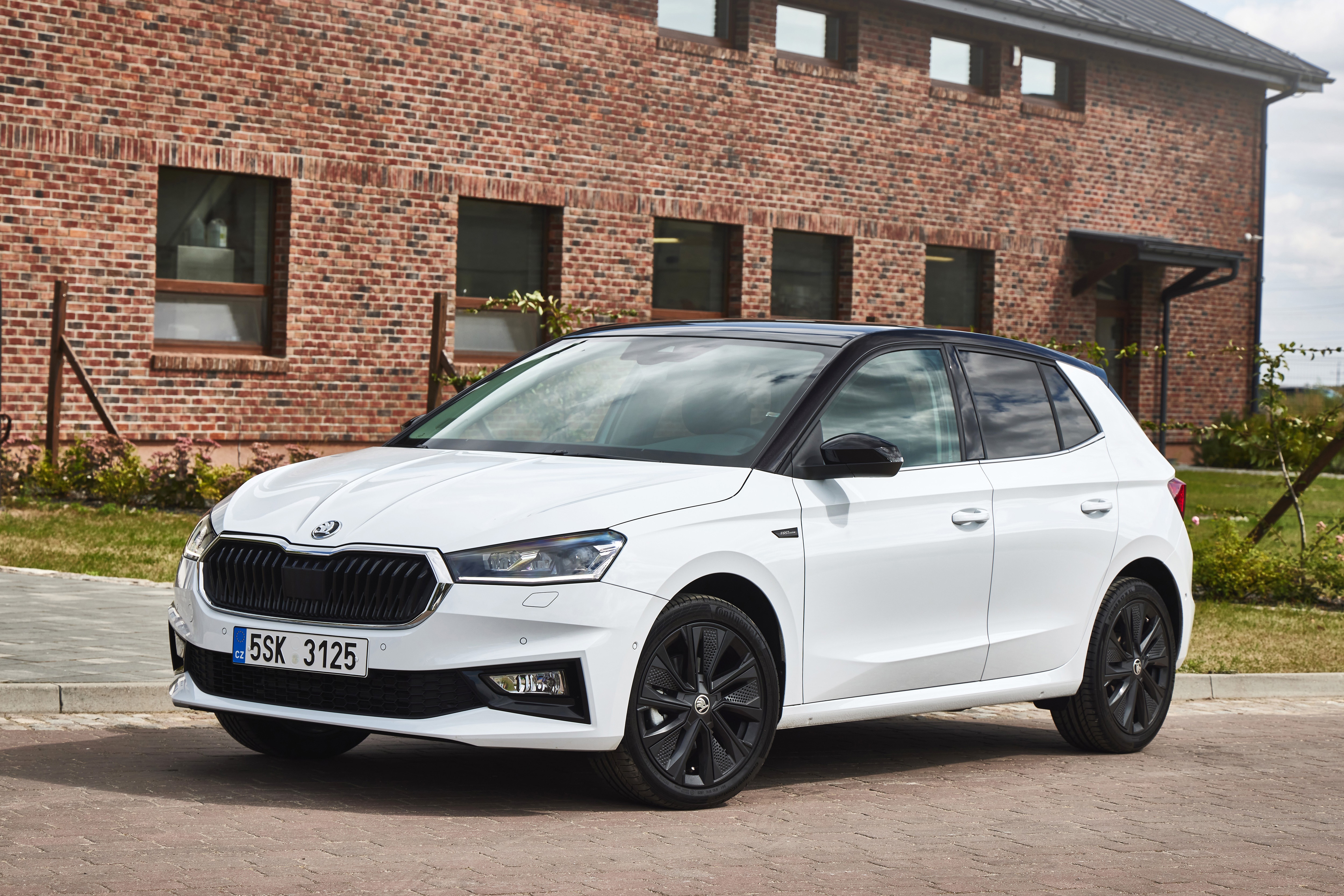 White Skoda Fabia 4K parked in front of a brick building HD Wallpaper