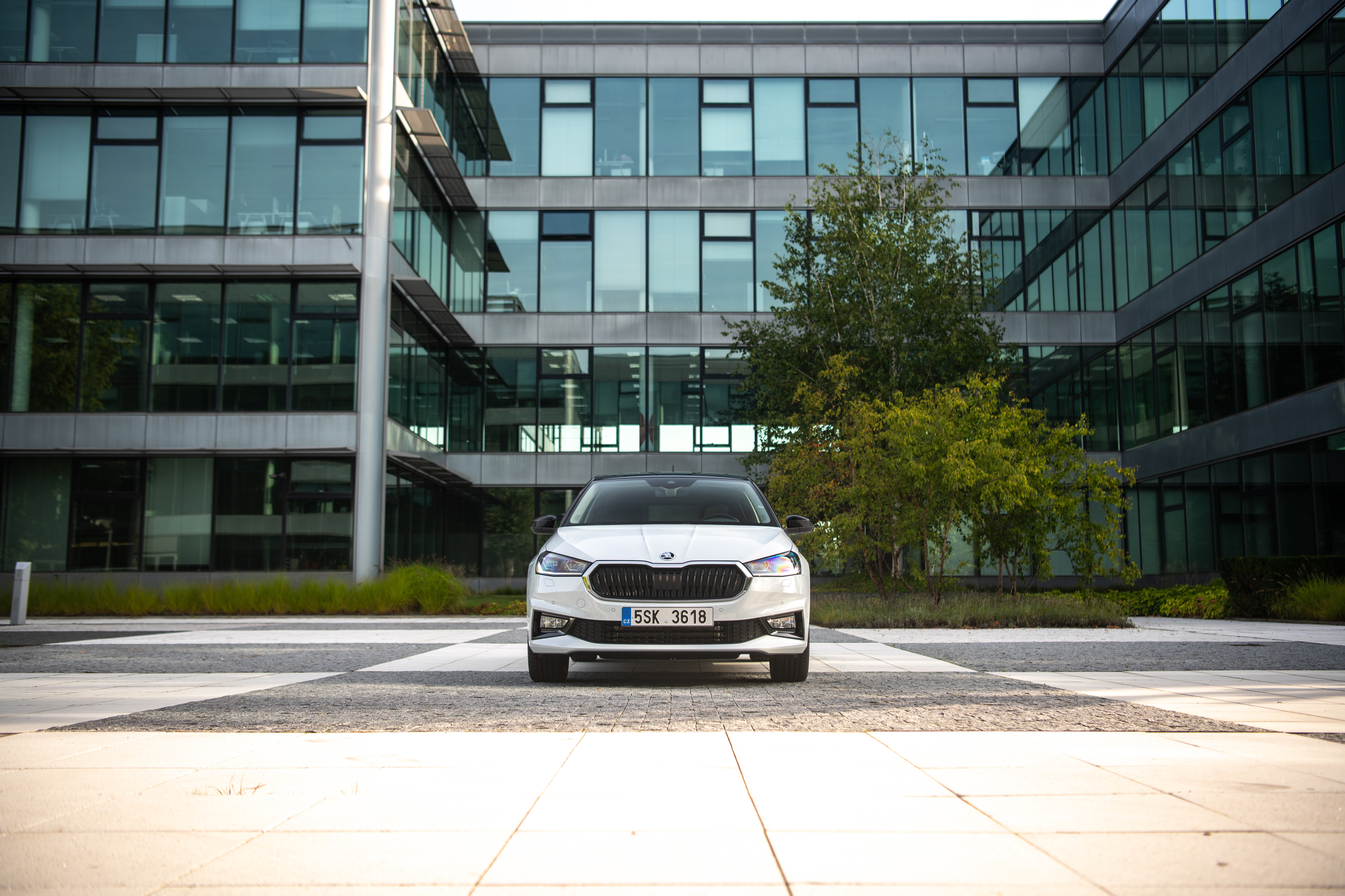 White Skoda Fabia parked in front of modern office building HD Wallpaper