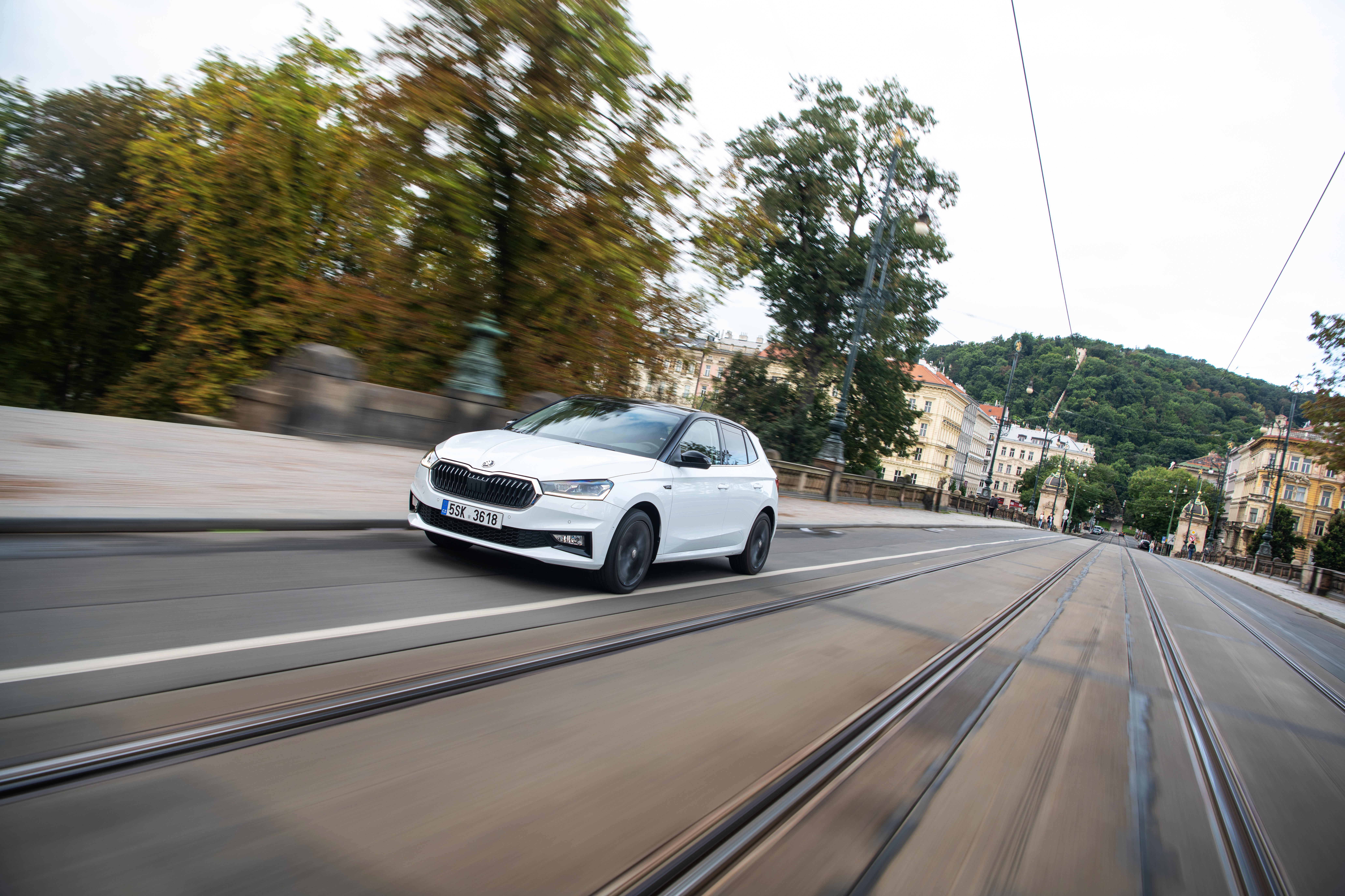 White Skoda Fabia driving on a city street HD Wallpaper