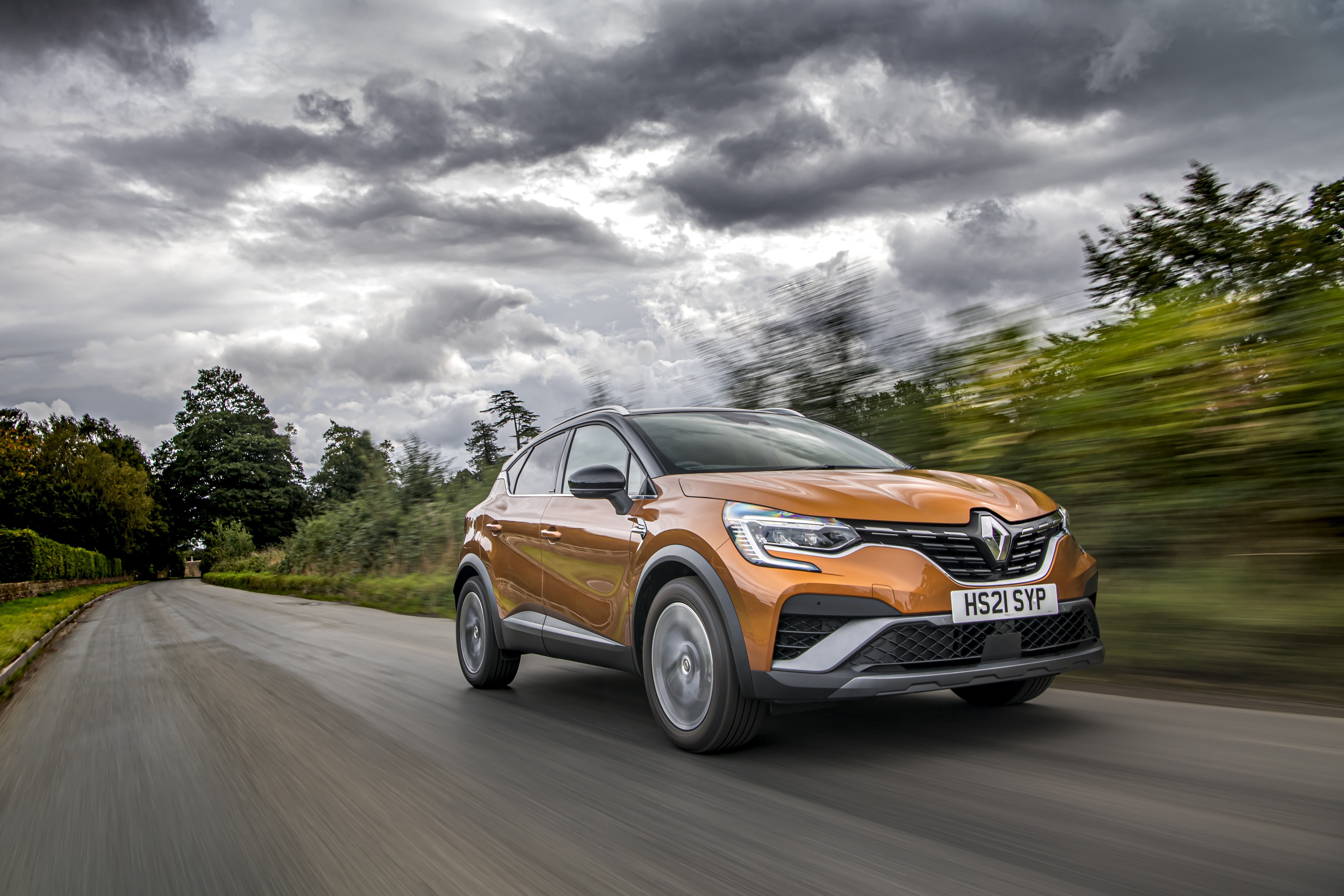 Renault Captur E-TECH Hybrid R.S. Line driving on a road HD Wallpaper