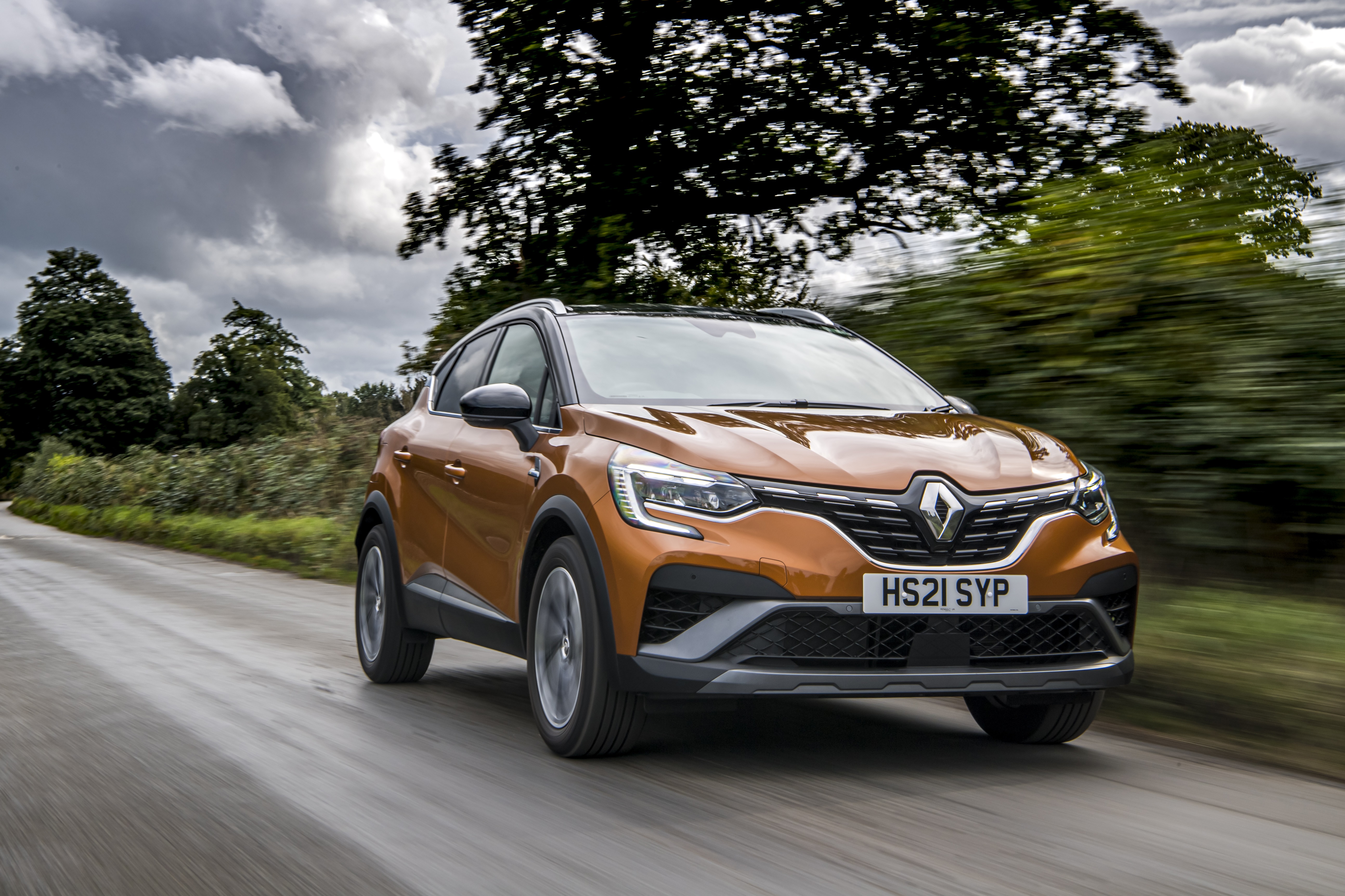 Renault Captur E-TECH Hybrid R.S. Line driving on a road HD Wallpaper