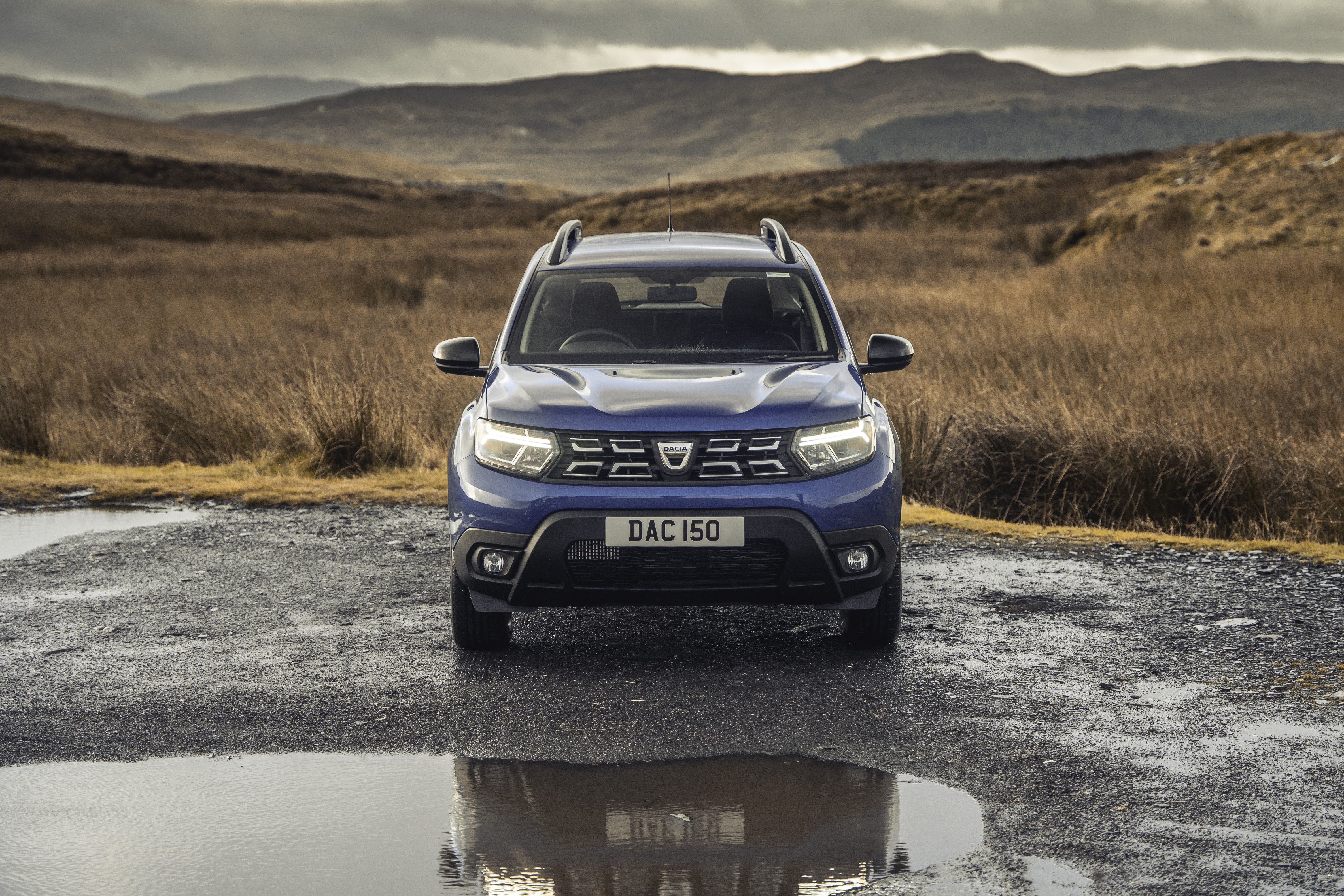 Blue Dacia Duster SUV in a rural landscape HD Wallpaper