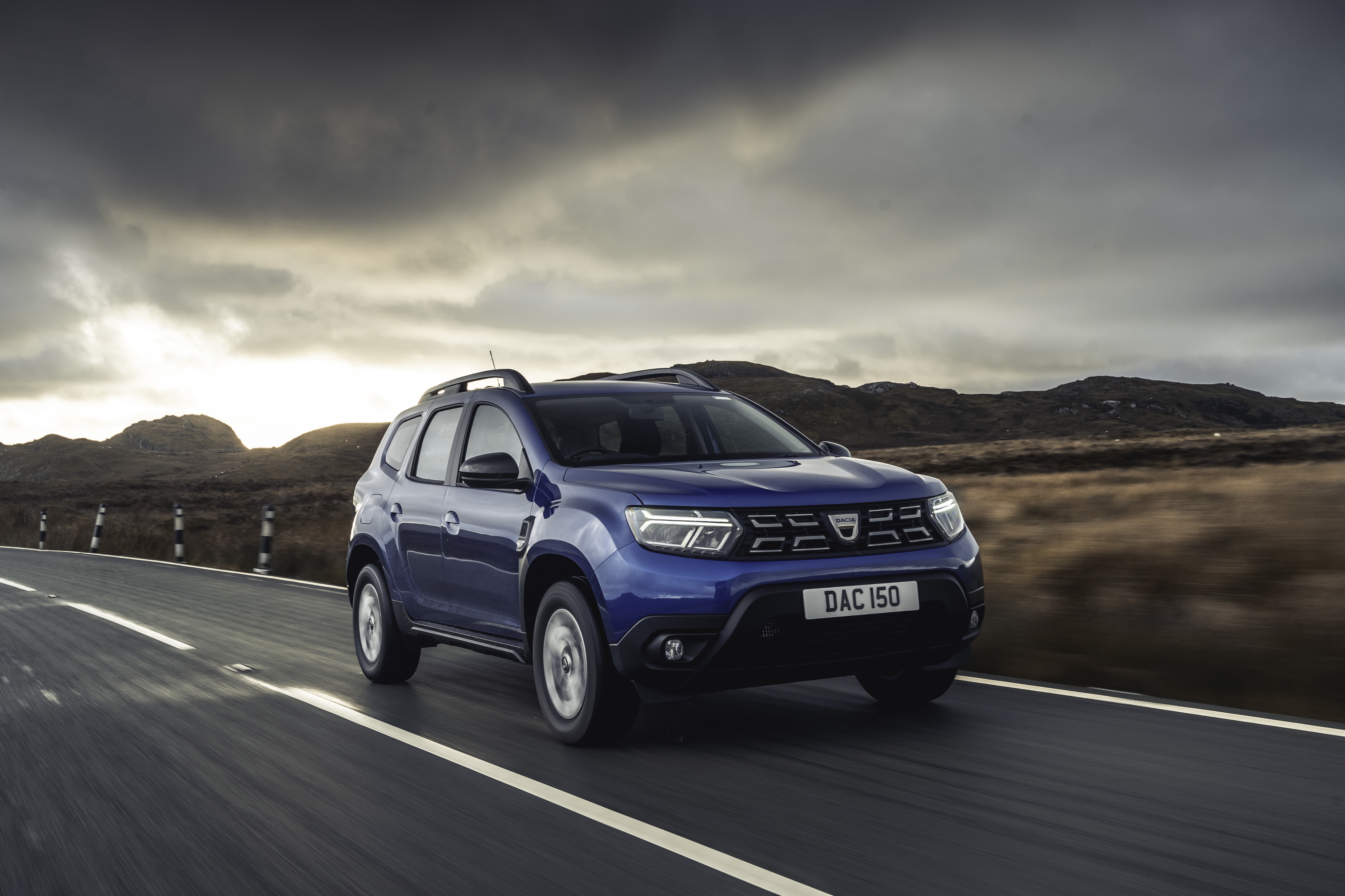 Blue Dacia Duster driving on a road HD Wallpaper