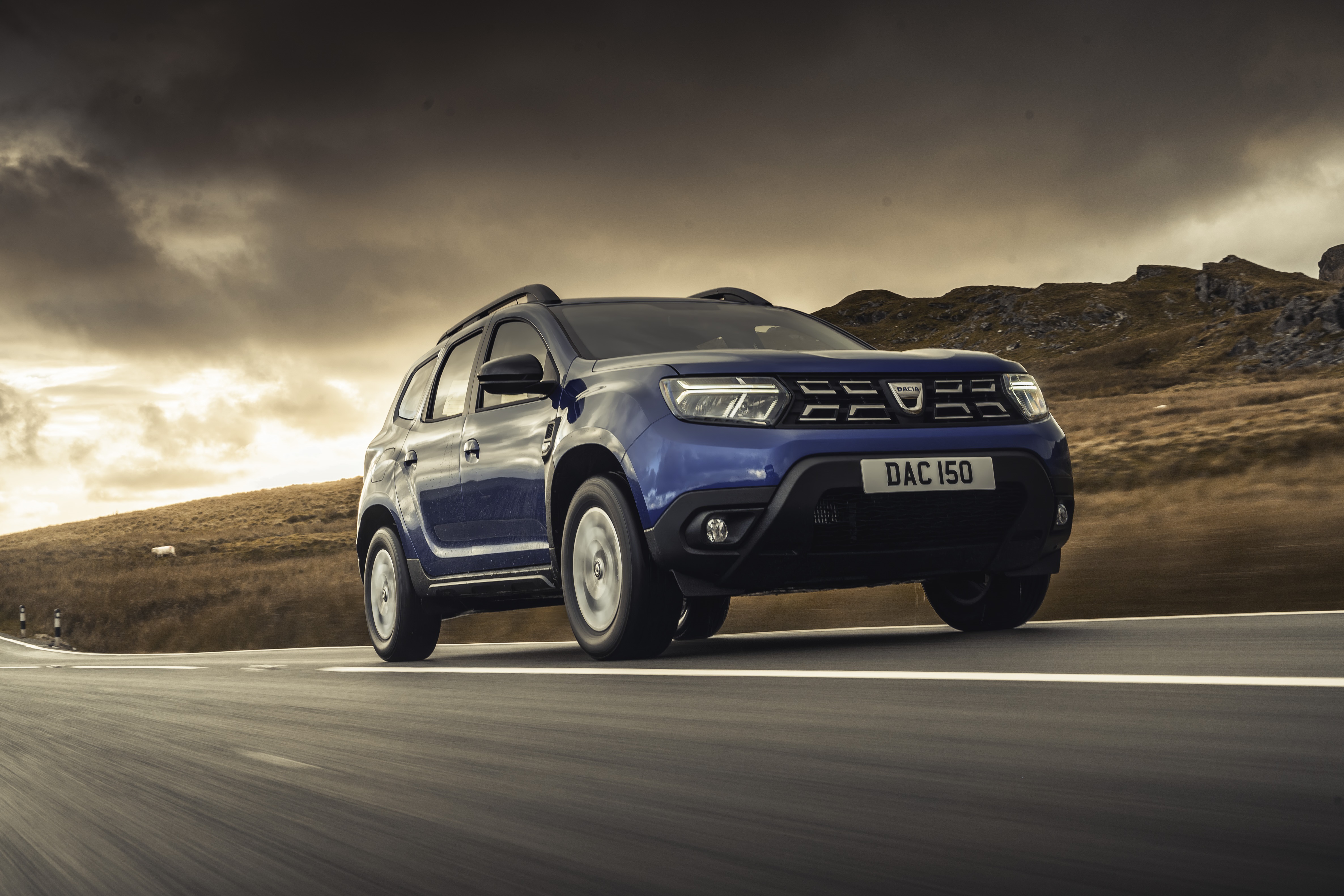Blue Dacia Duster 4K SUV driving on a road HD Wallpaper