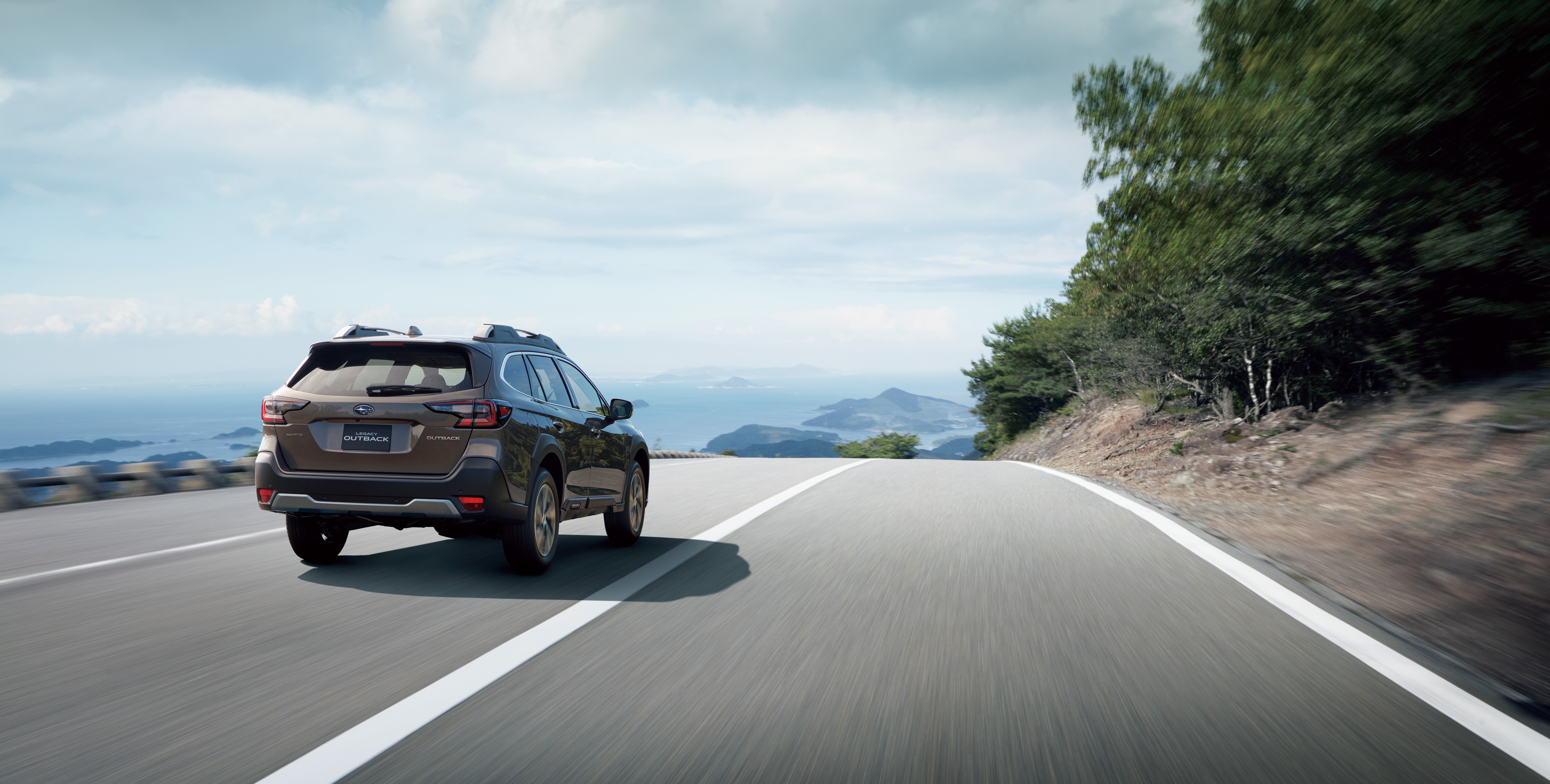 Subaru Outback driving on a coastal road HD Wallpaper