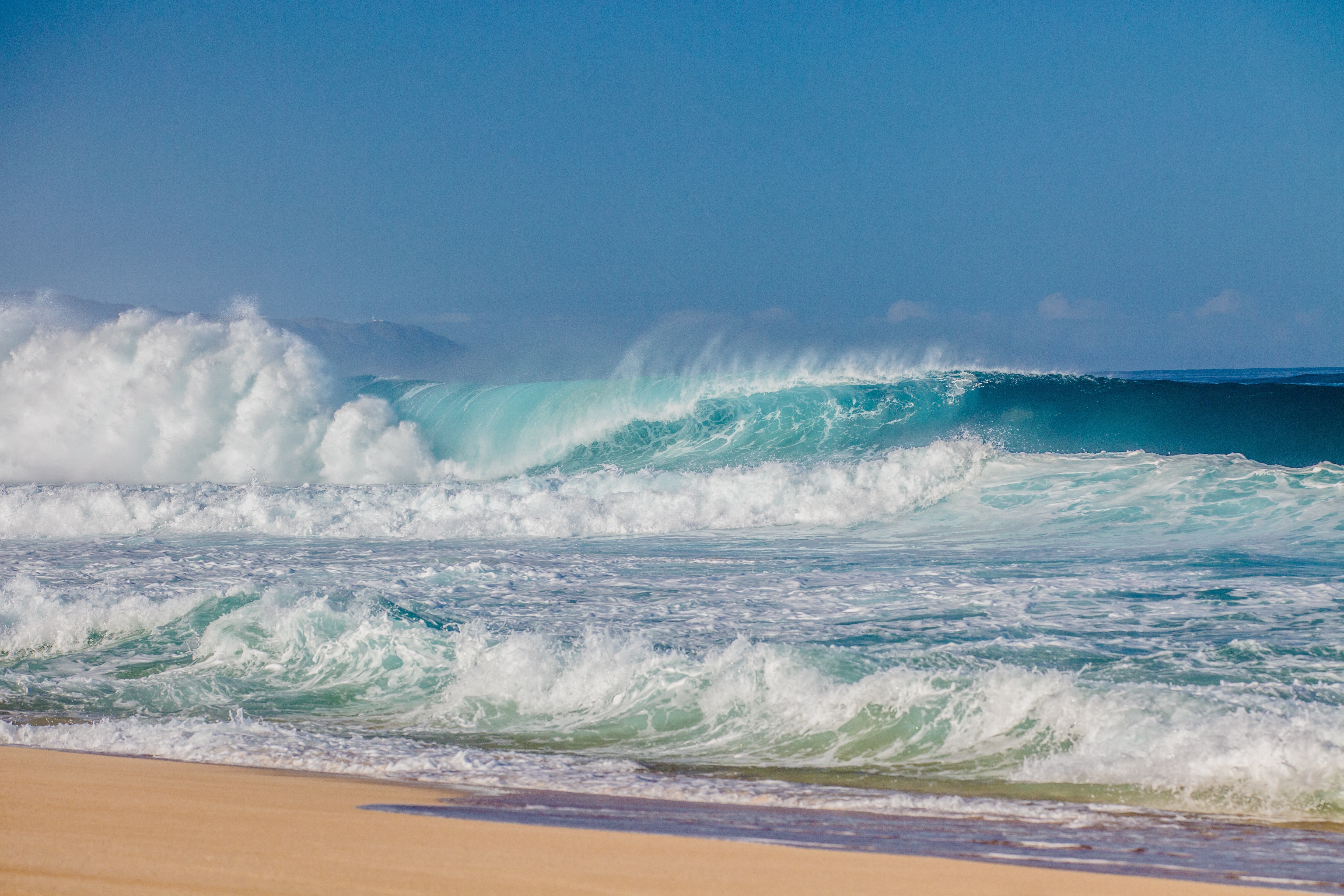 Ocean waves crashing on a sandy beach HD Wallpaper