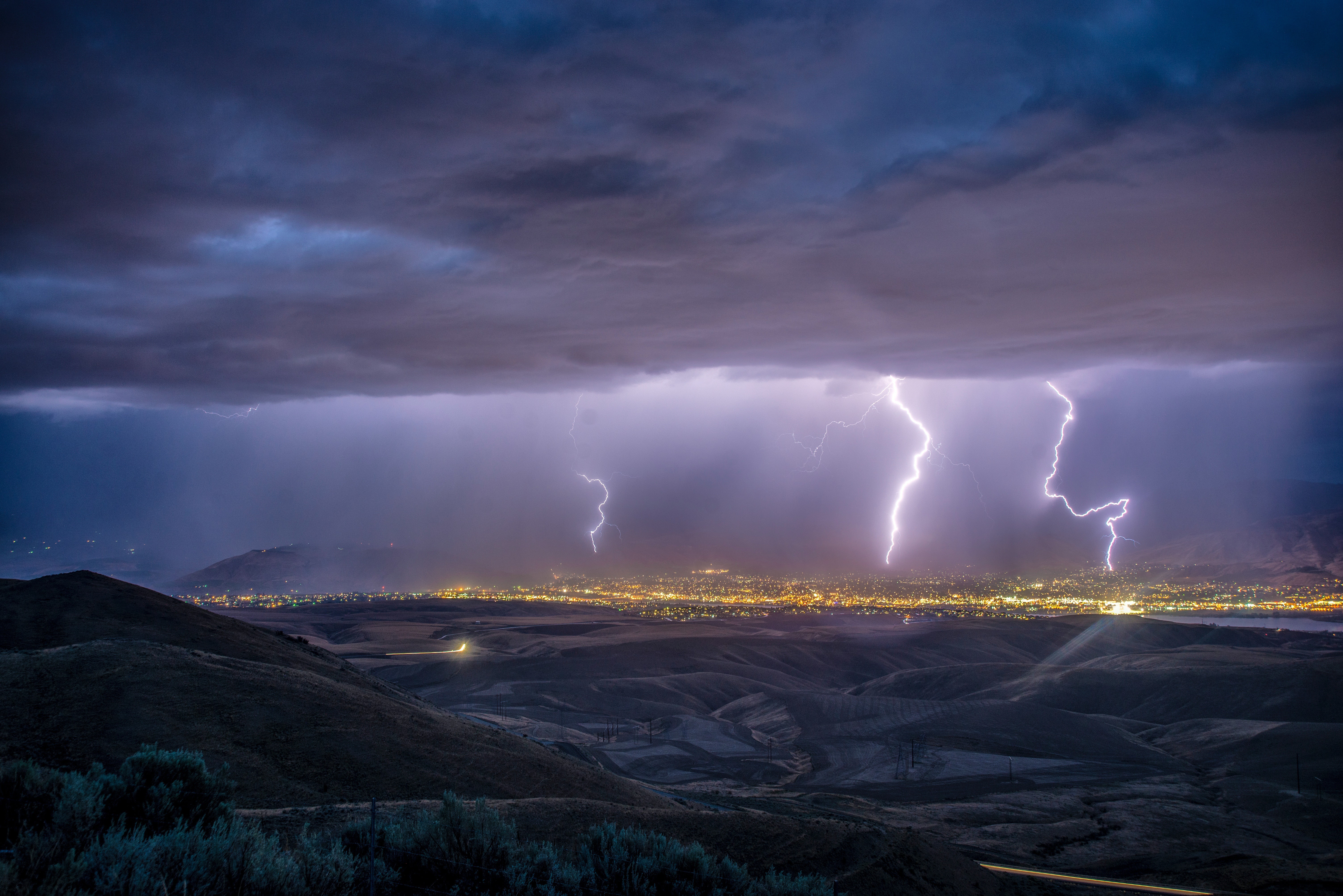 Lightning strikes over a city at night HD Wallpaper