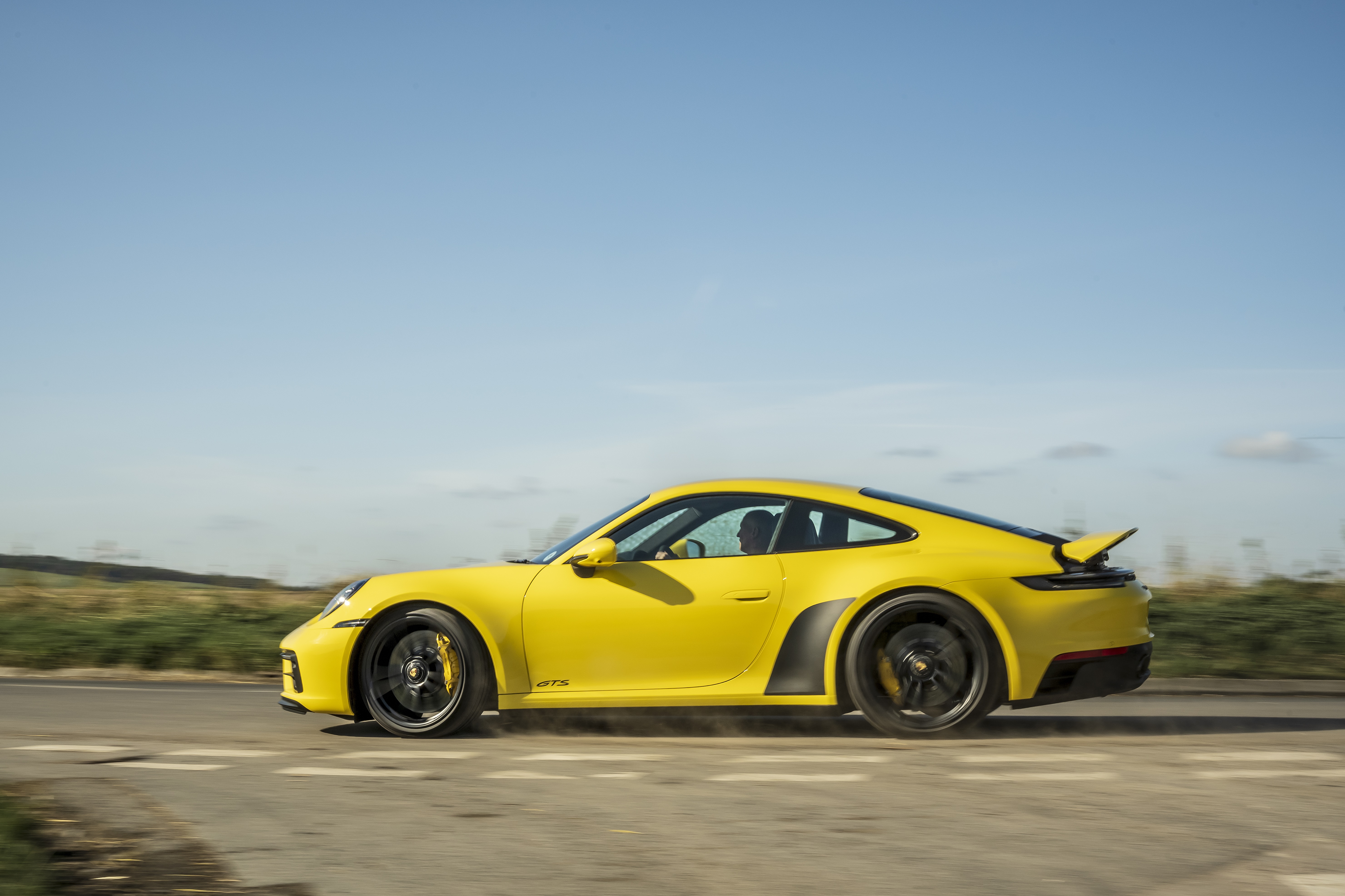 Yellow Porsche 911 Carrera GTS driving on road HD Wallpaper