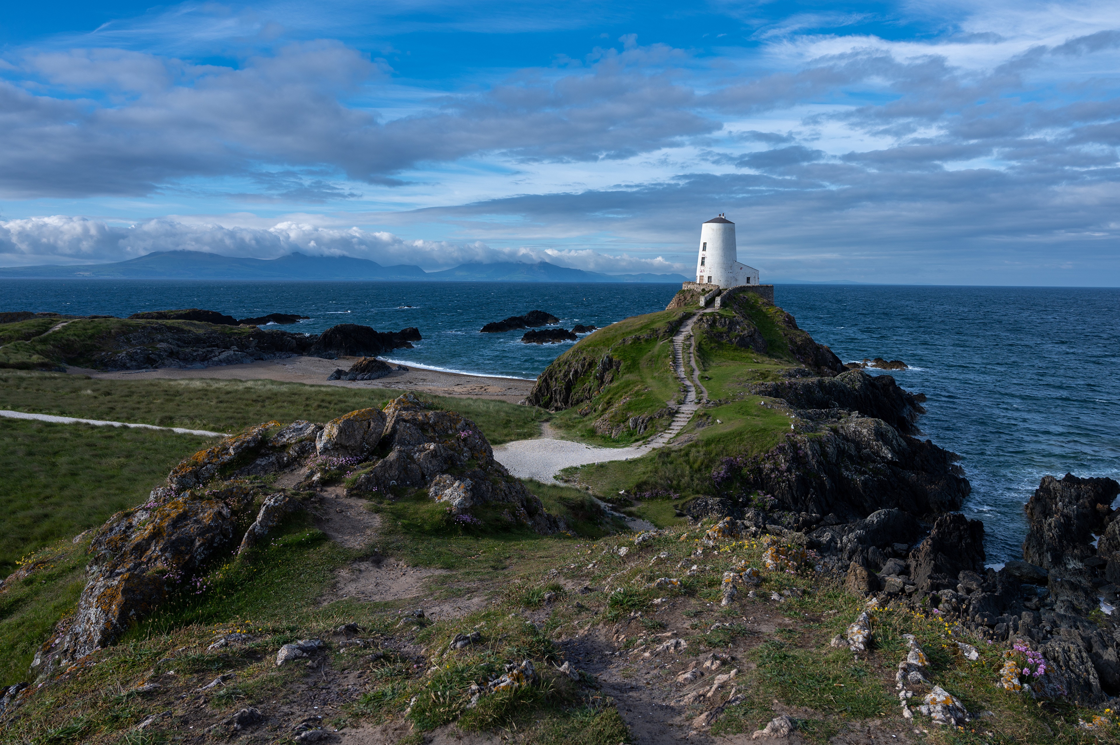 Lighthouse on a rocky coast in Wales 4K HD Wallpaper