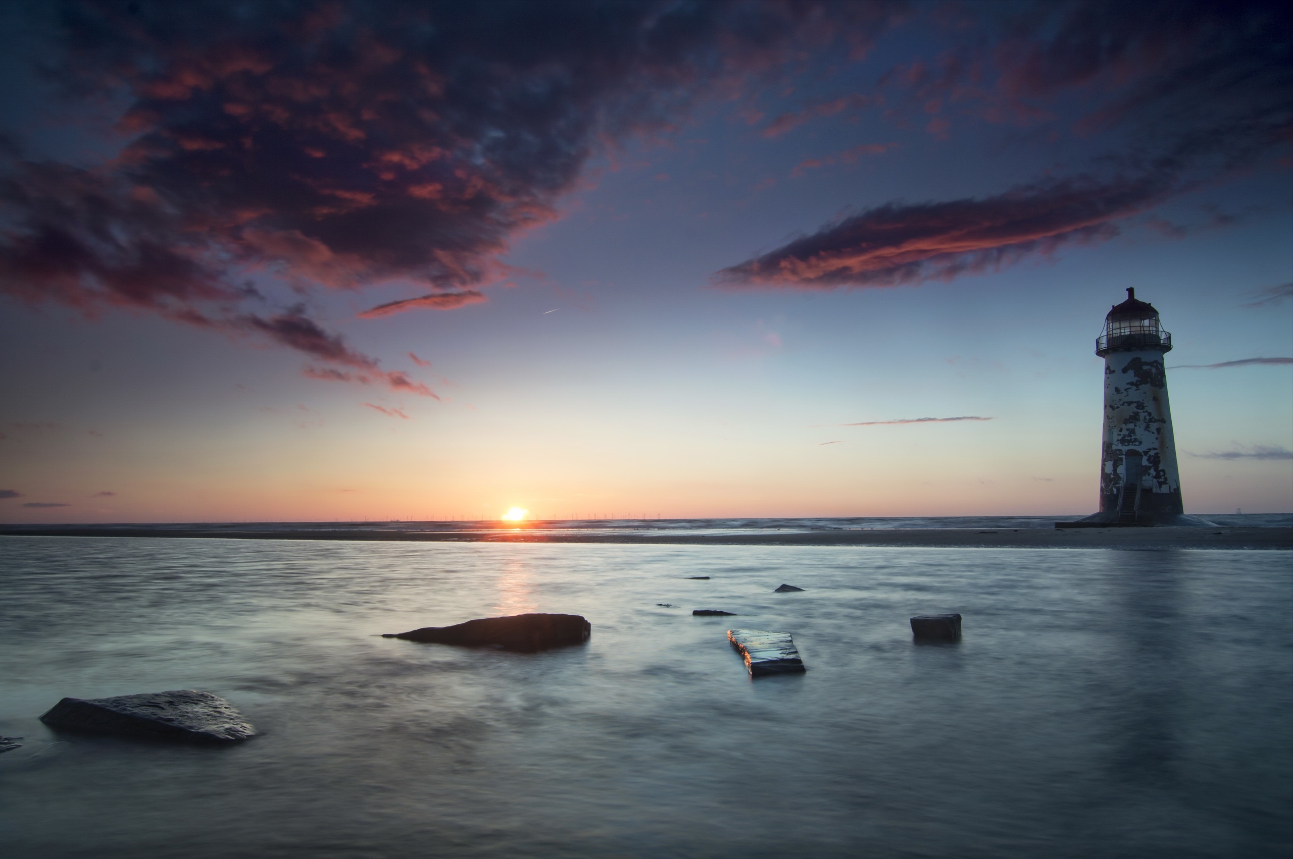 Lighthouse at sunset over the sea HD Wallpaper