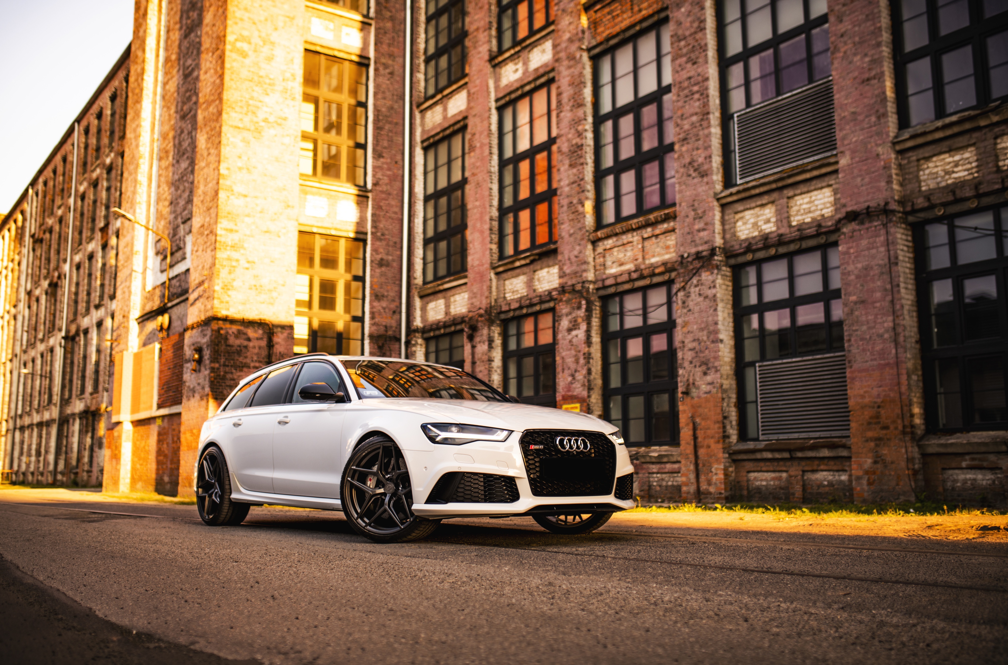 White Audi RS6 Avant parked in front of brick building HD Wallpaper