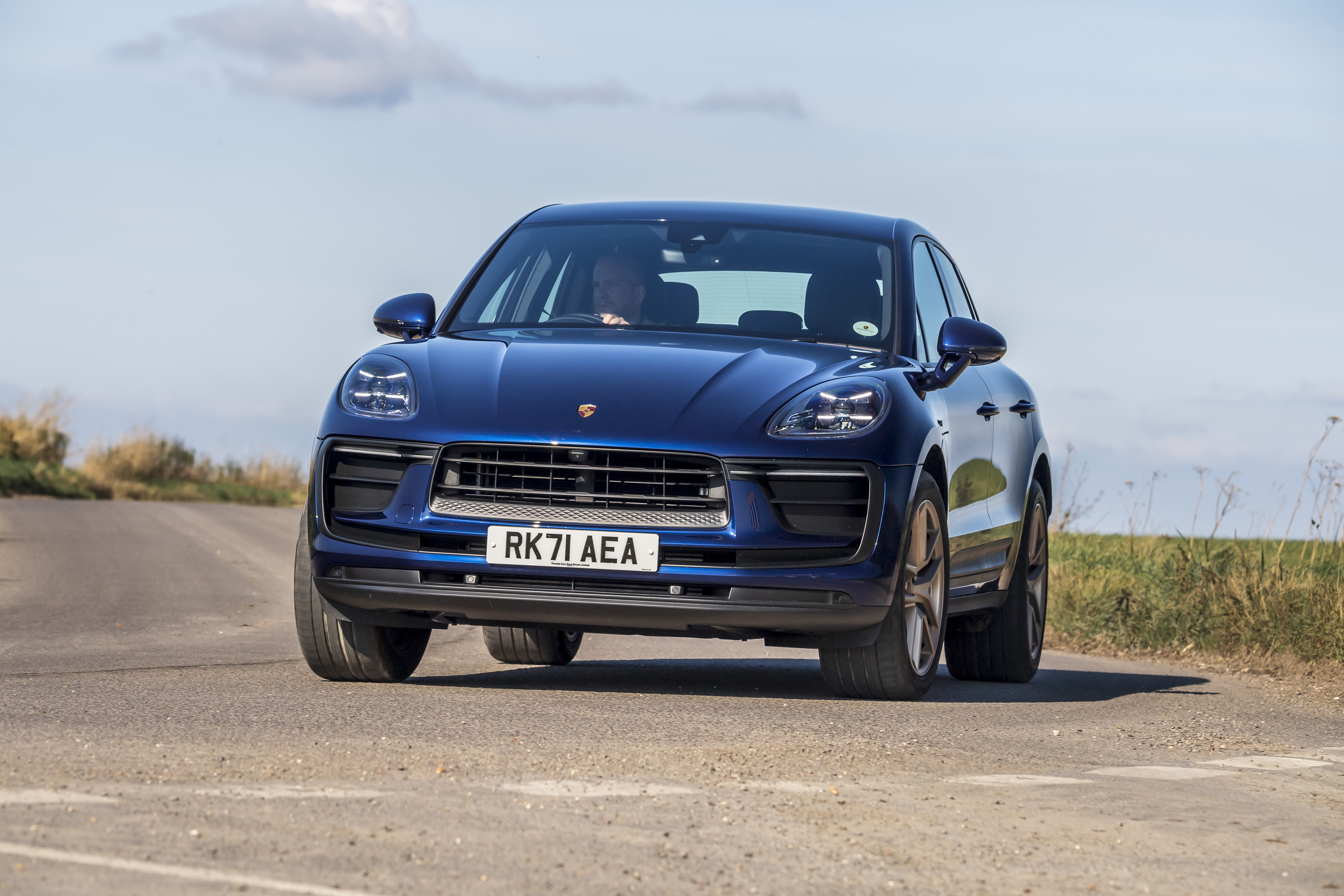Blue Porsche Macan driving on a road HD Wallpaper