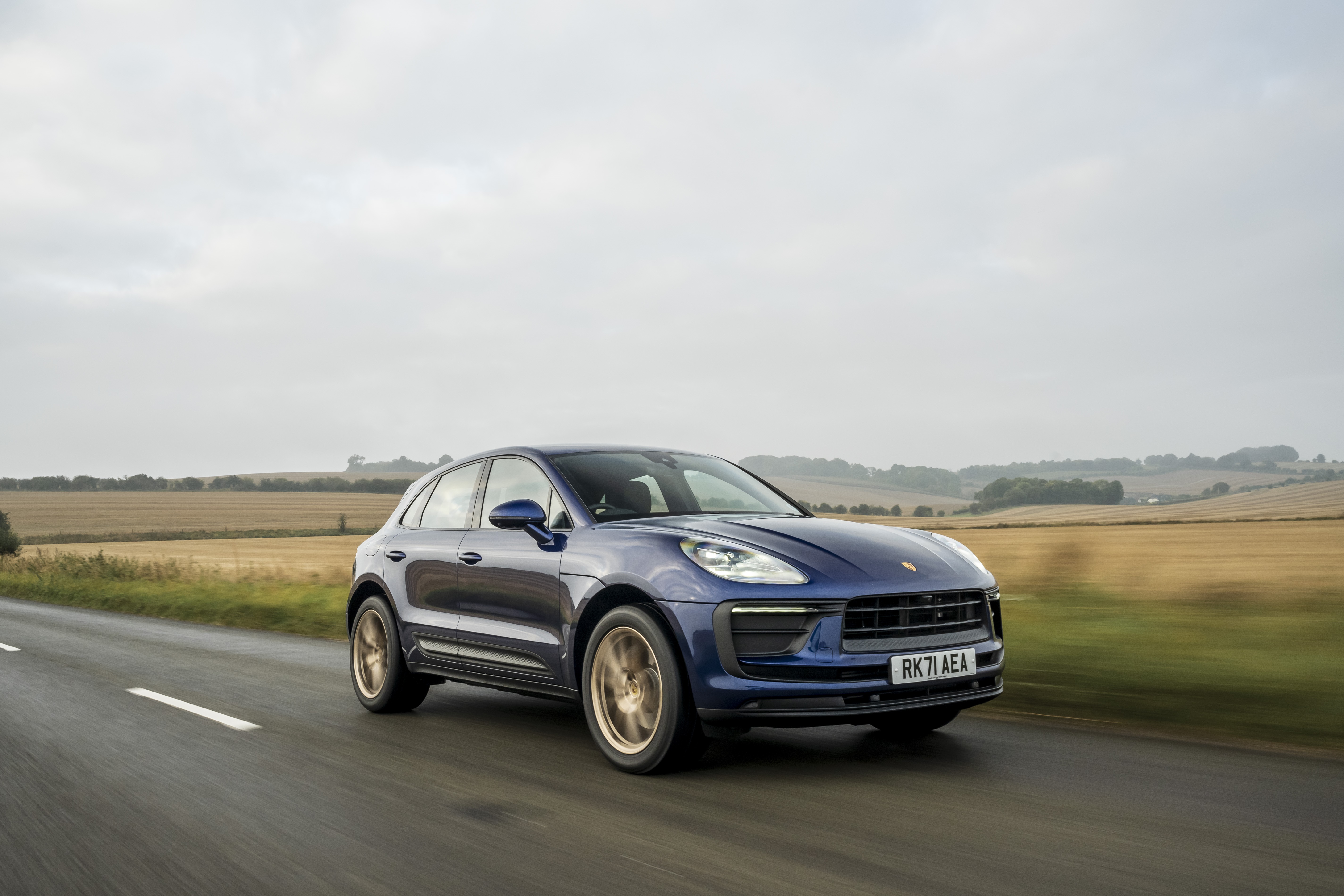Blue Porsche Macan SUV driving on a road HD Wallpaper