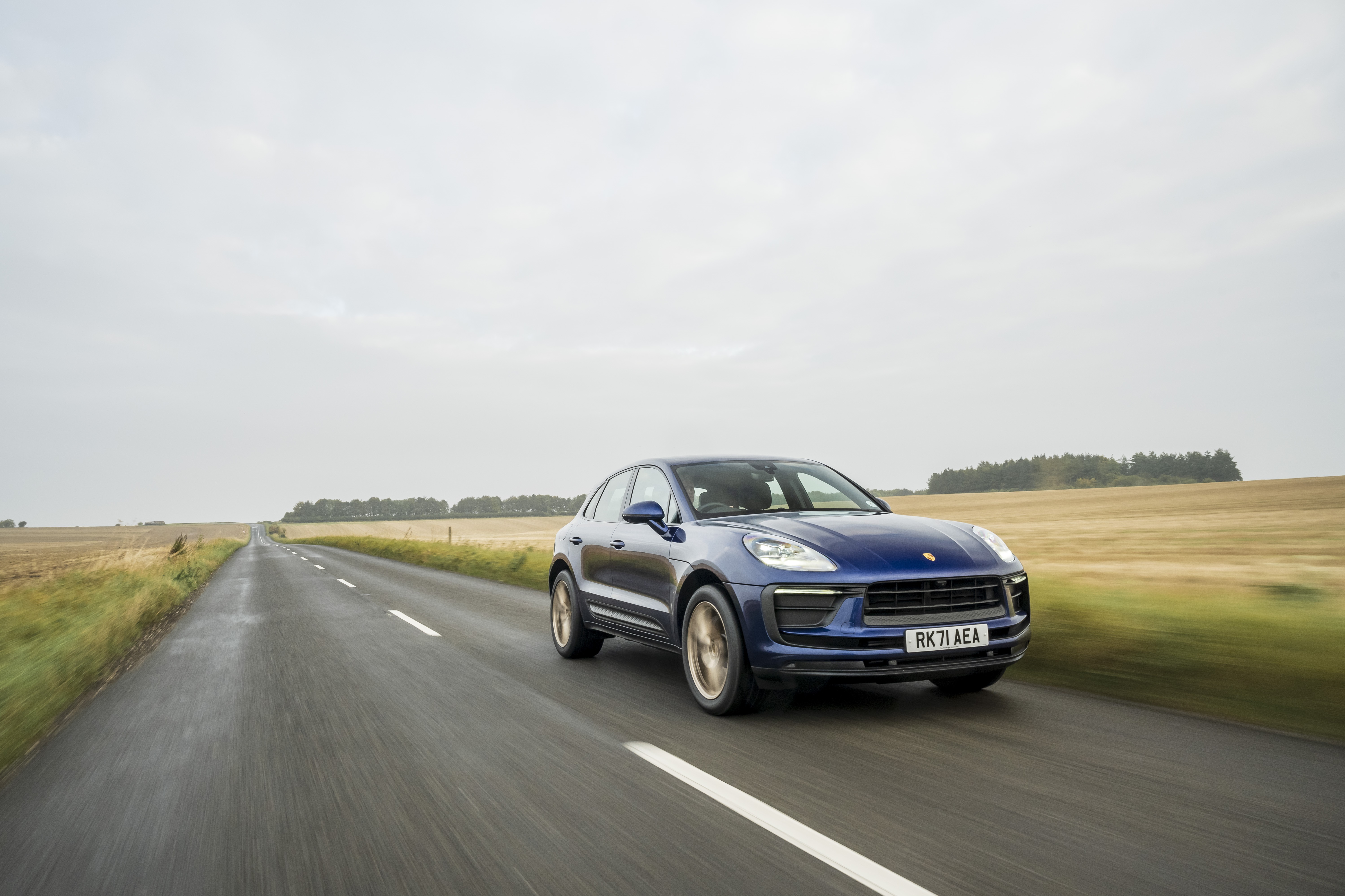 Blue Porsche Macan driving on a wet road HD Wallpaper