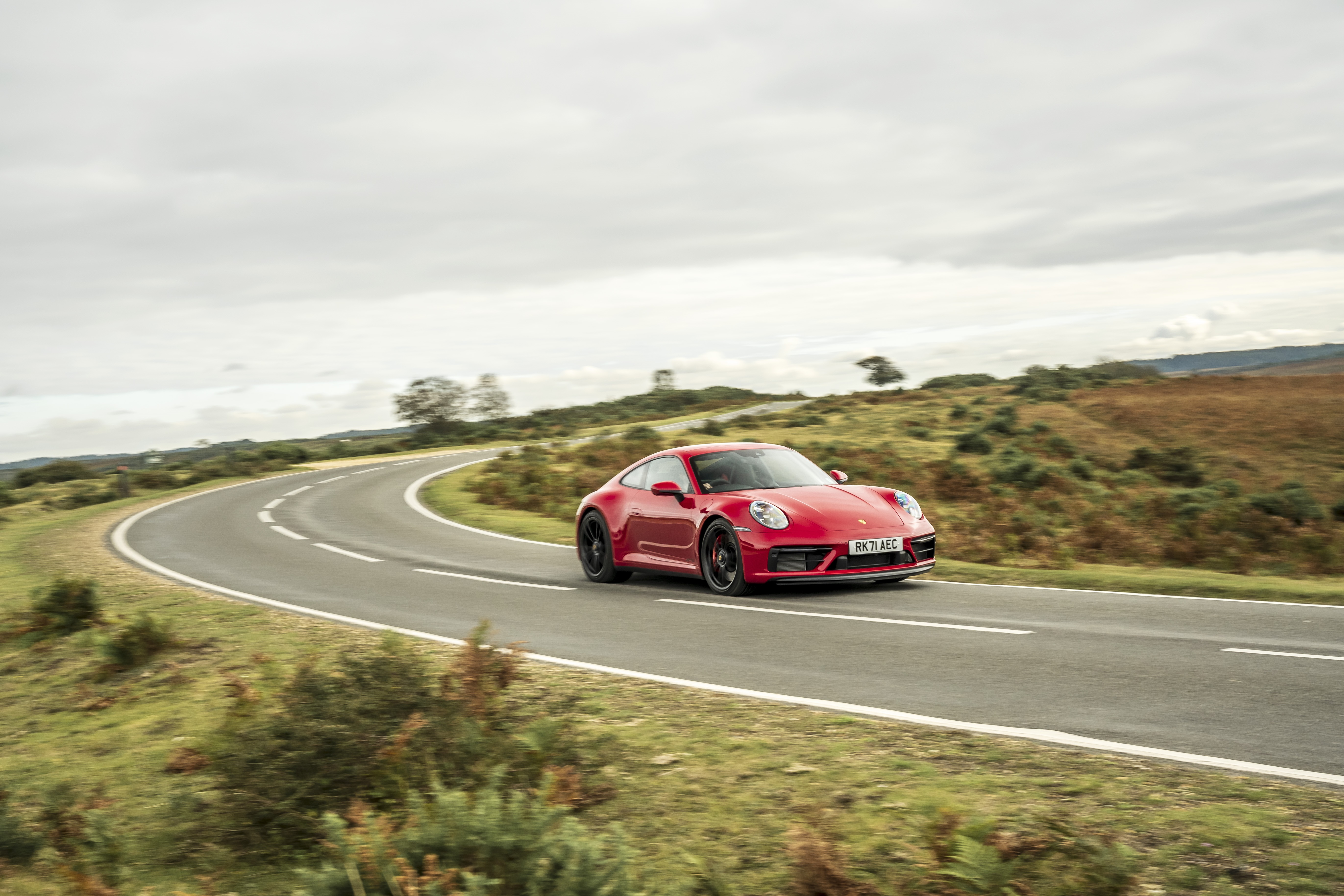 Red Porsche 911 Carrera GTS on a winding road HD Wallpaper