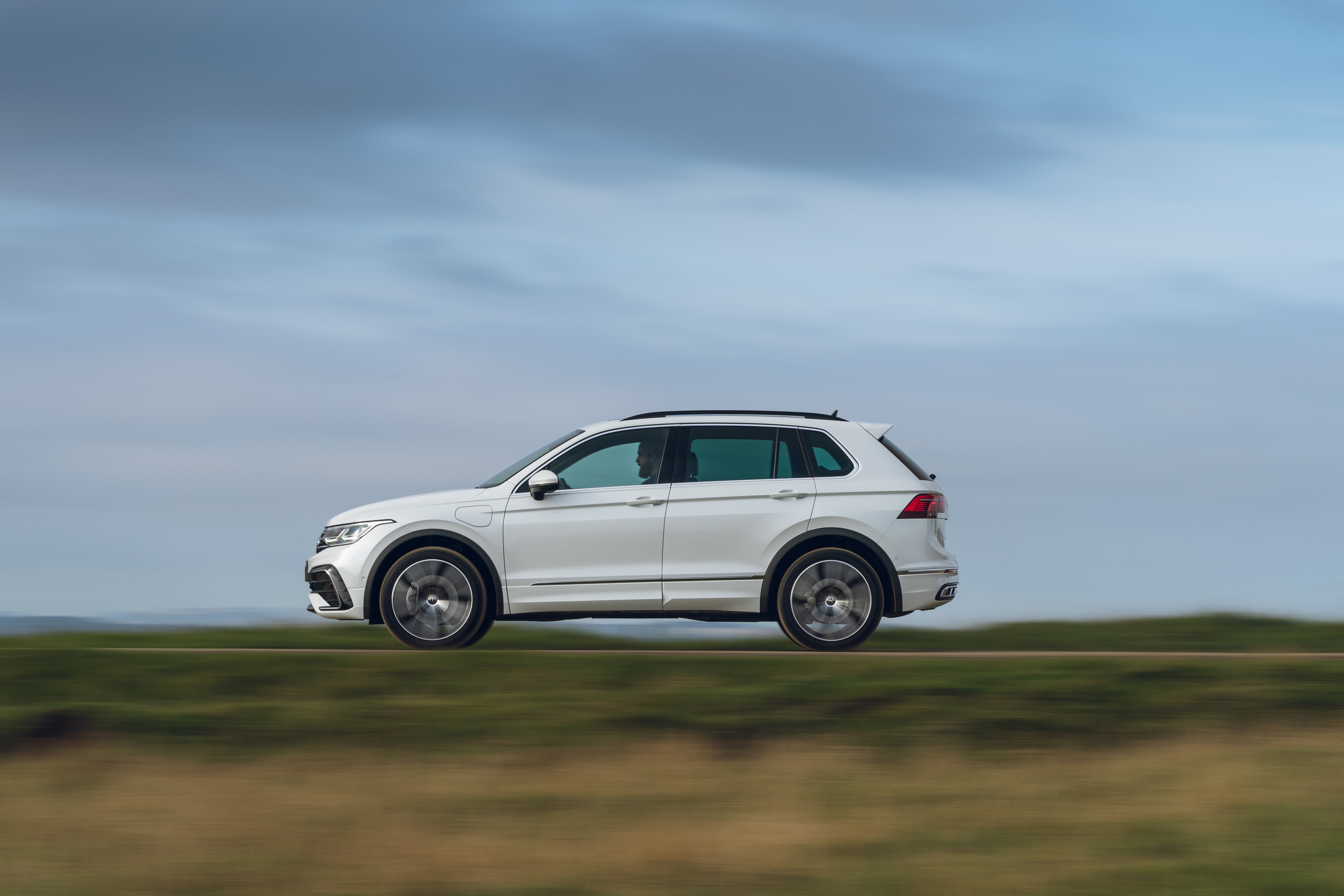 White Volkswagen Tiguan eHybrid R-Line driving on a road HD Wallpaper
