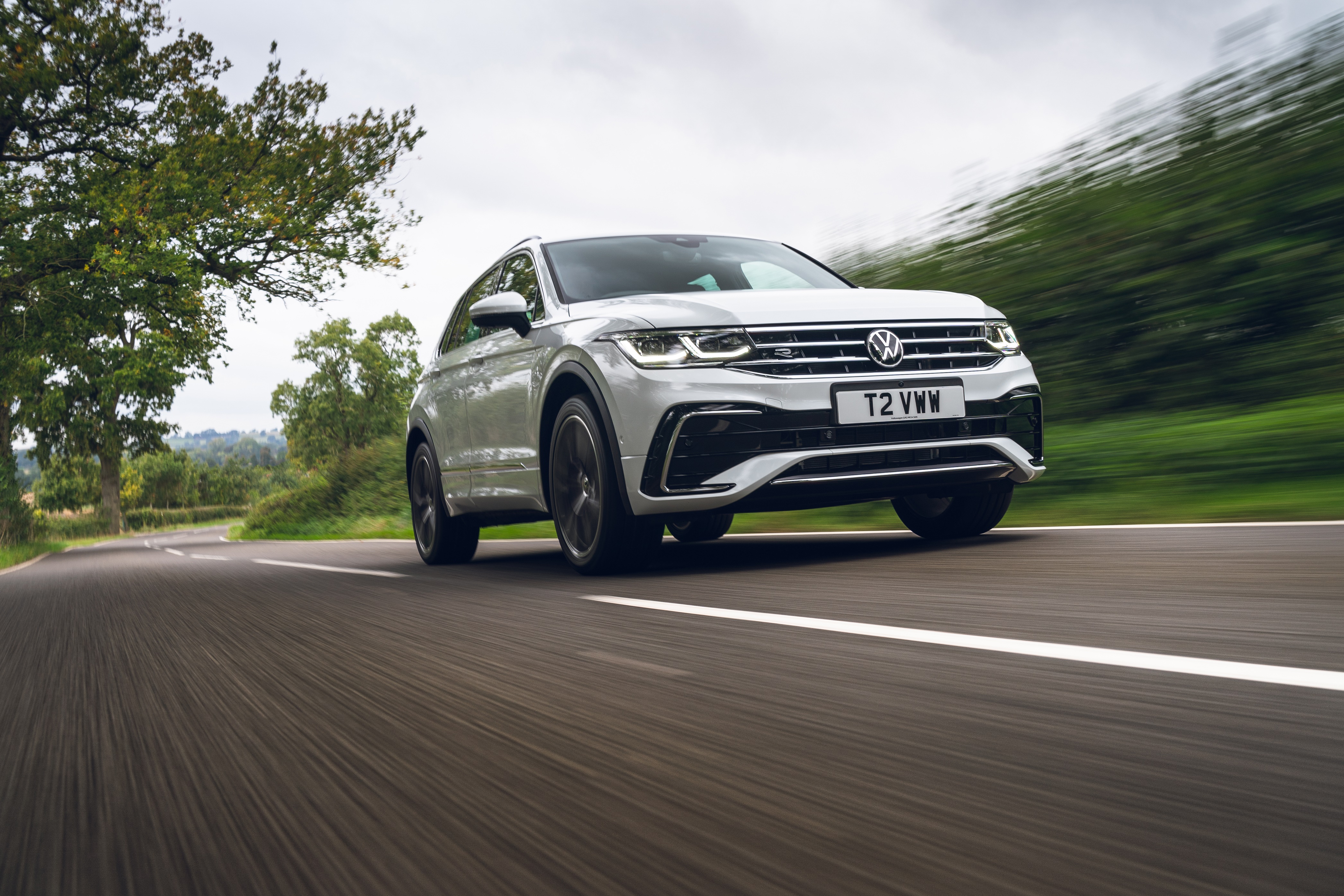 White Volkswagen Tiguan R-Line driving on a road HD Wallpaper