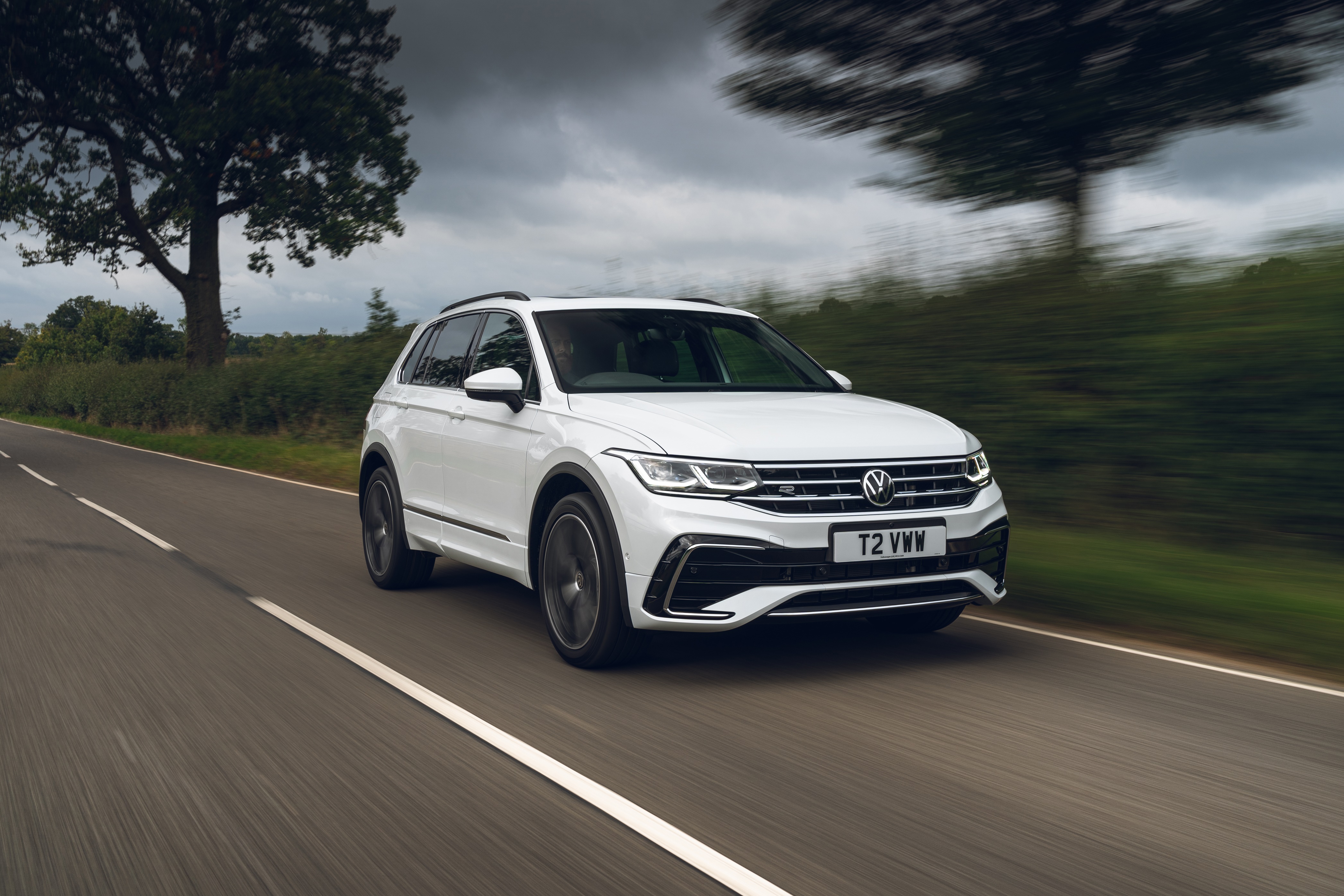 White Volkswagen Tiguan R-Line driving on a road HD Wallpaper