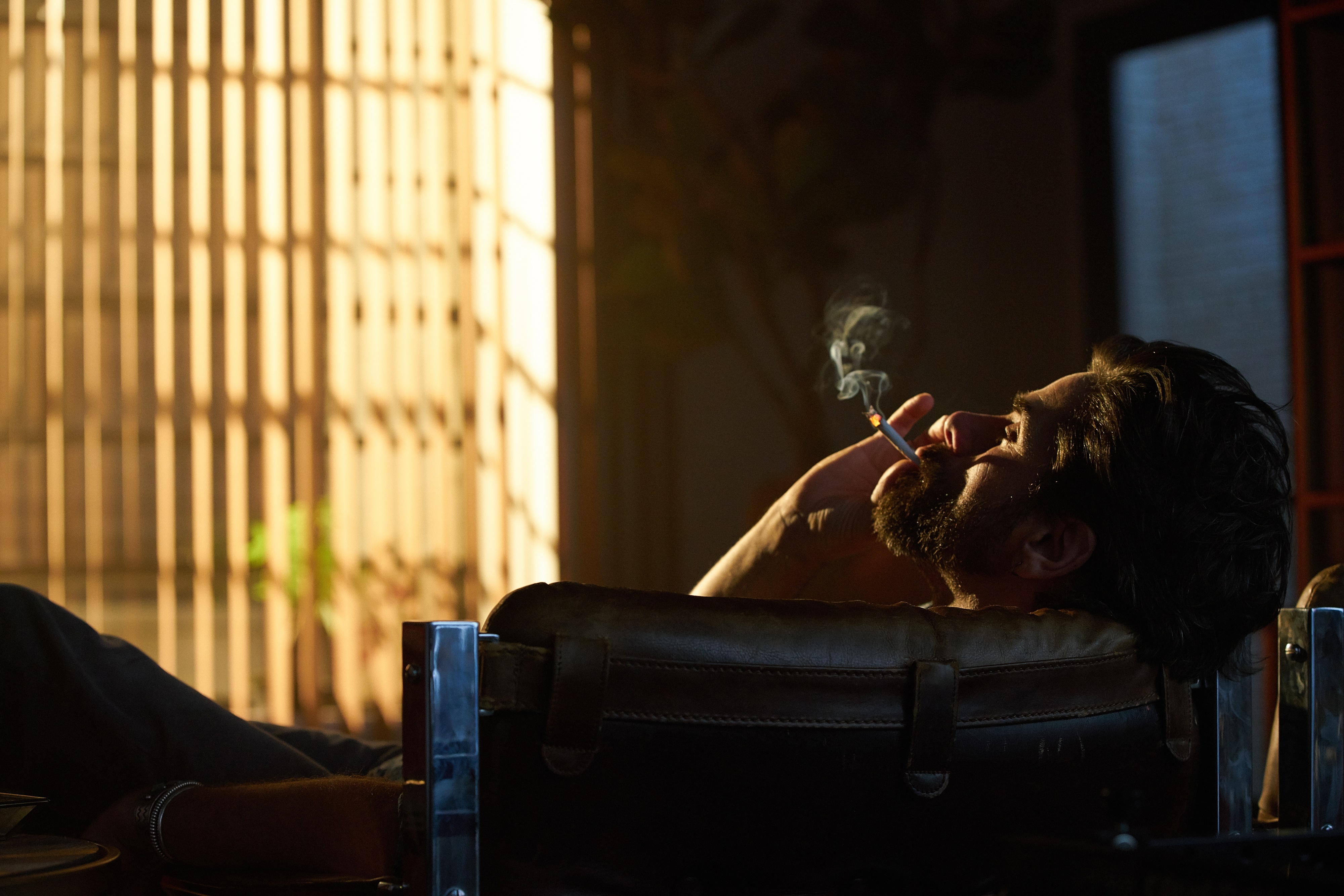 Man smoking in a chair 4K HD Wallpaper