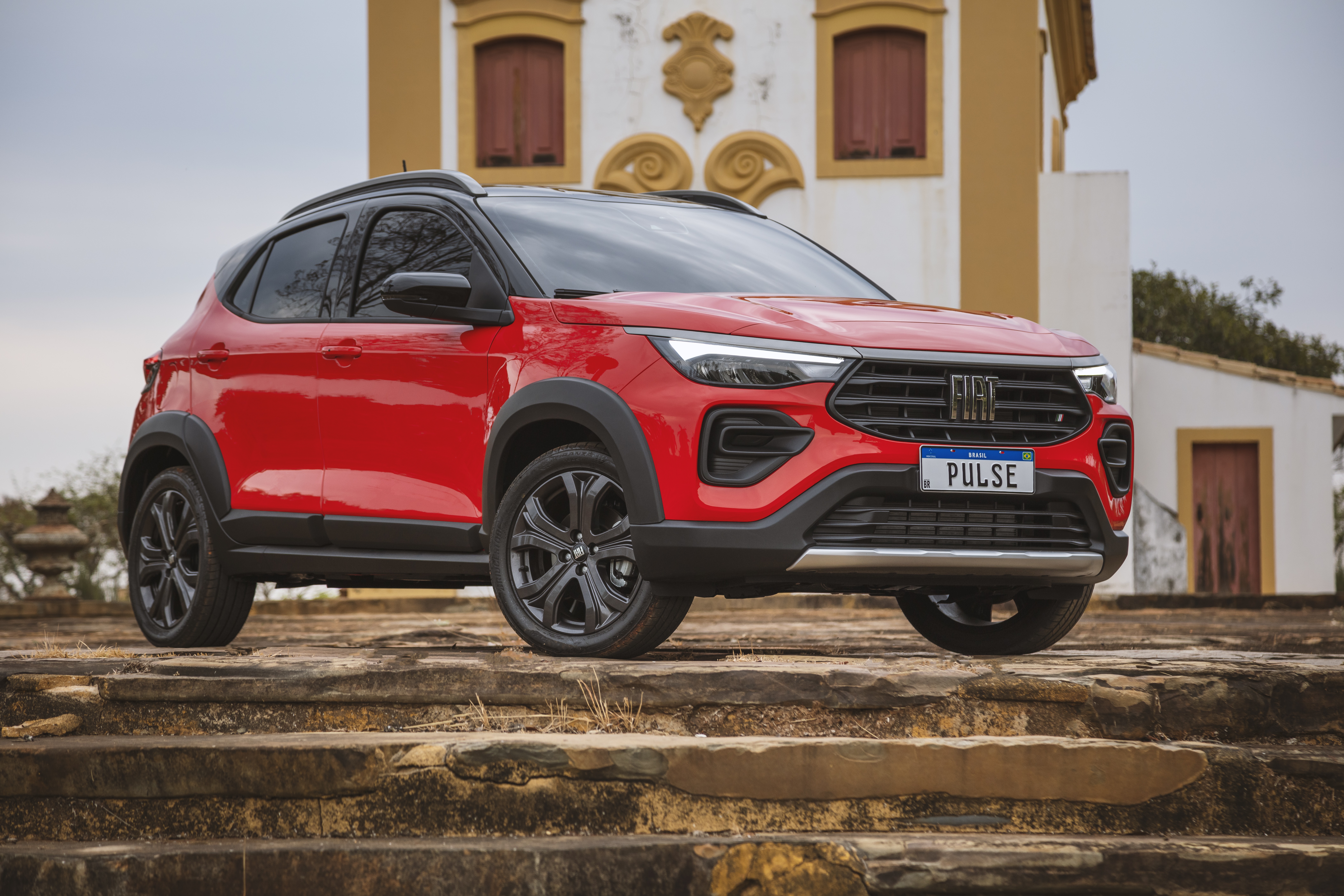 Red Fiat Pulse SUV parked on stone steps HD Wallpaper