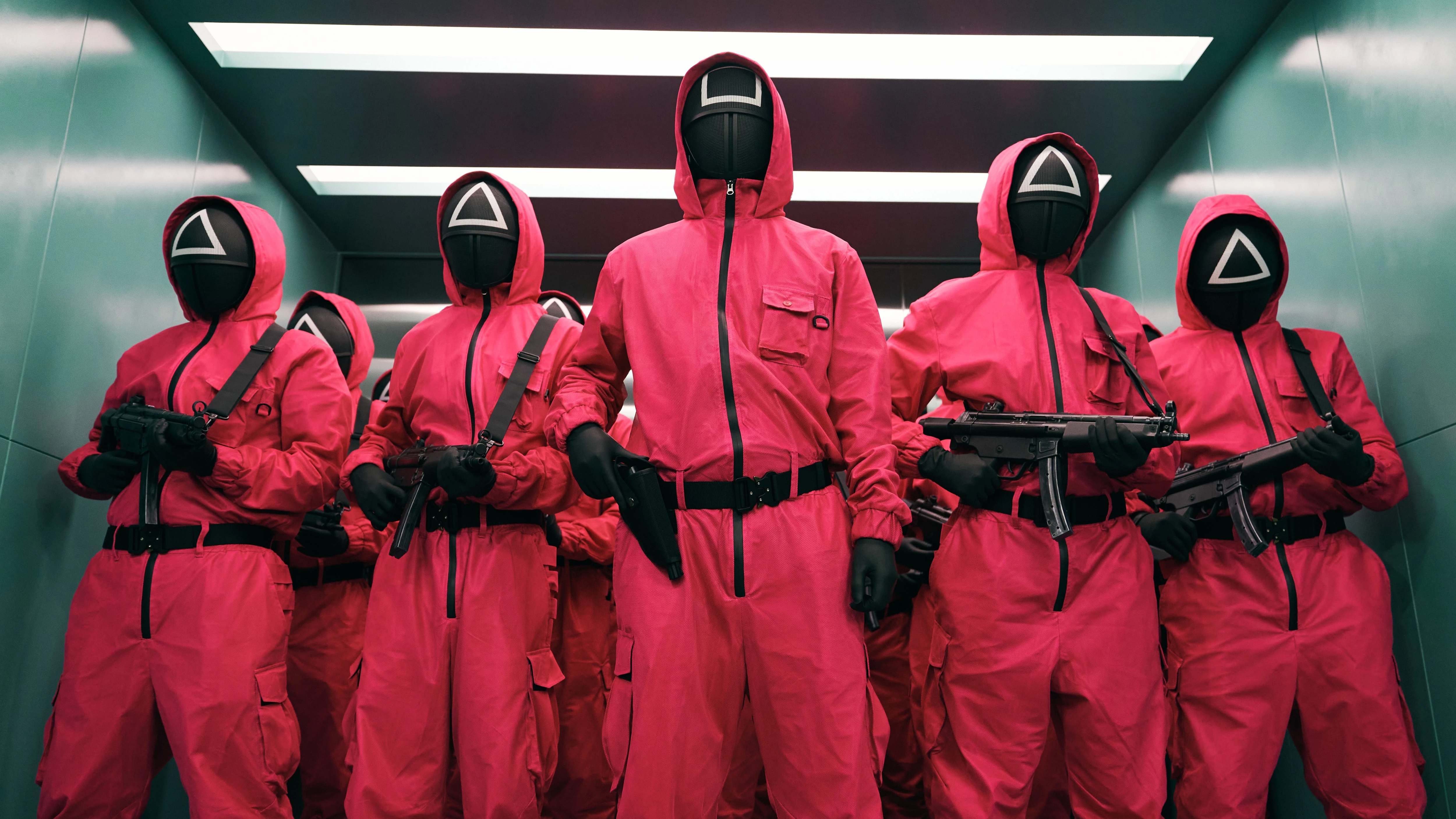 Squid Game guards in pink suits with masks HD Wallpaper