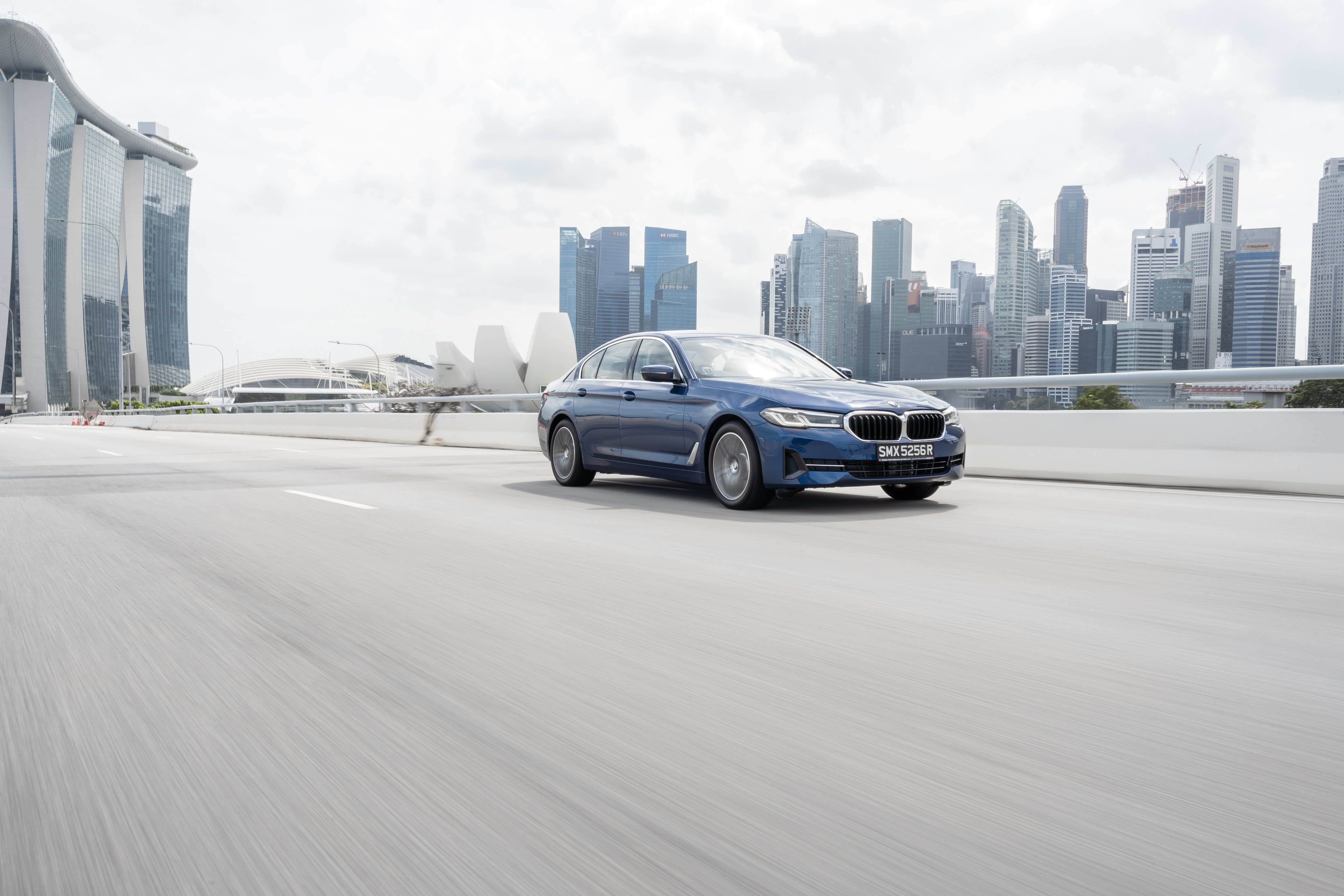 Blue BMW 5 Series 530e Luxury Line driving in Singapore HD Wallpaper