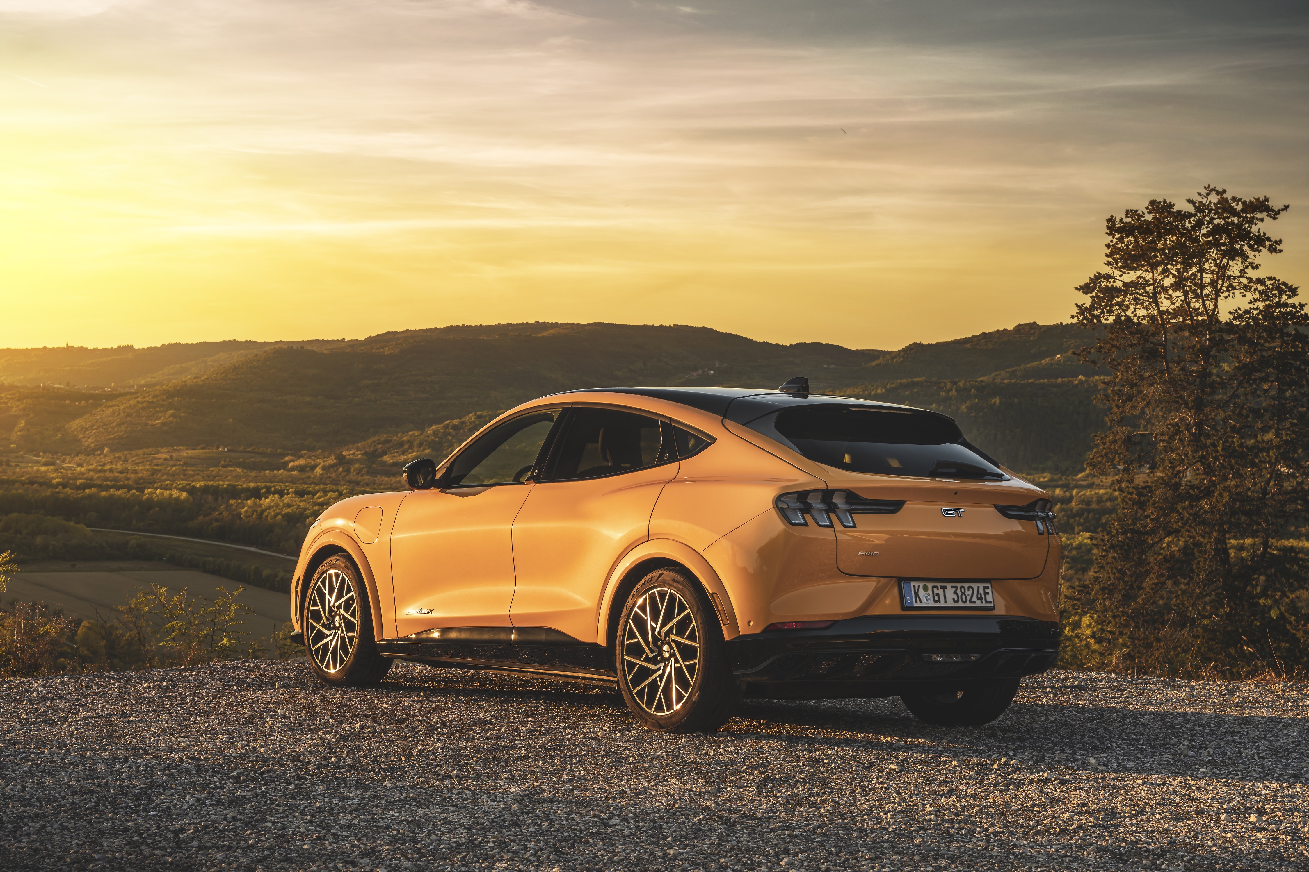 Ford Mustang Mach-E GT parked on gravel with sunset background HD Wallpaper