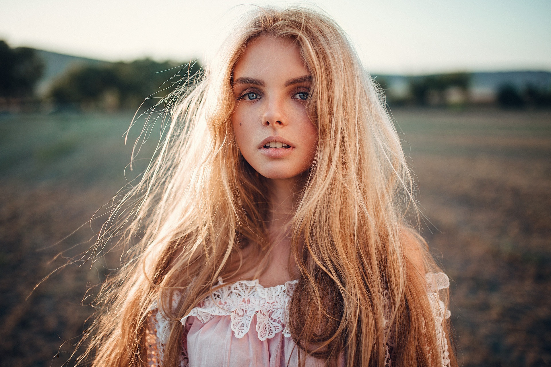 Young woman with long blonde hair in a field HD Wallpaper